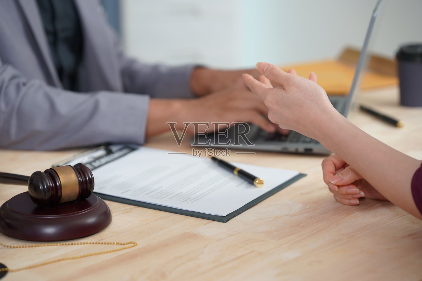 法官正在提供法律建议,以解释在签署讨论各种案件之前对女商人的咨询条款和条件。分析文件并制定谈判策略。照片摄影图片