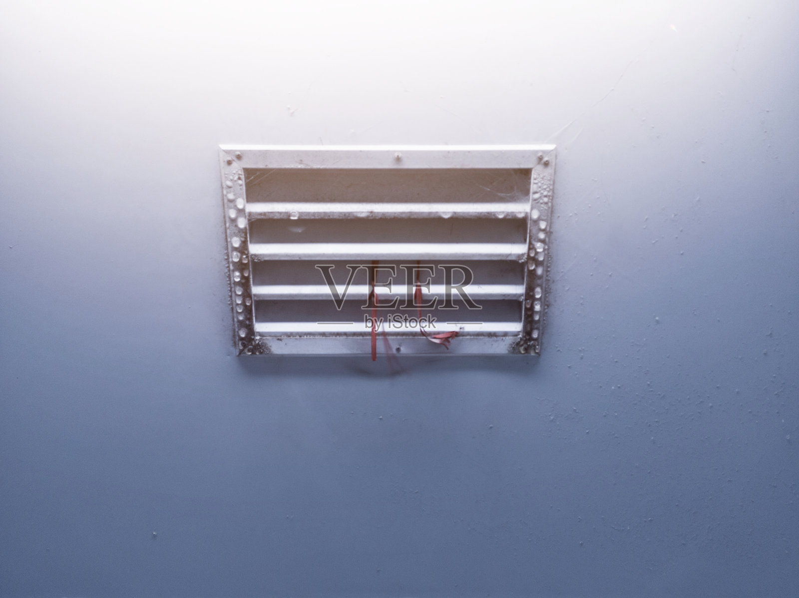 屋顶走廊房间的冷却空气通风系统出现了冷凝现象,墙面上有水滴。照片摄影图片