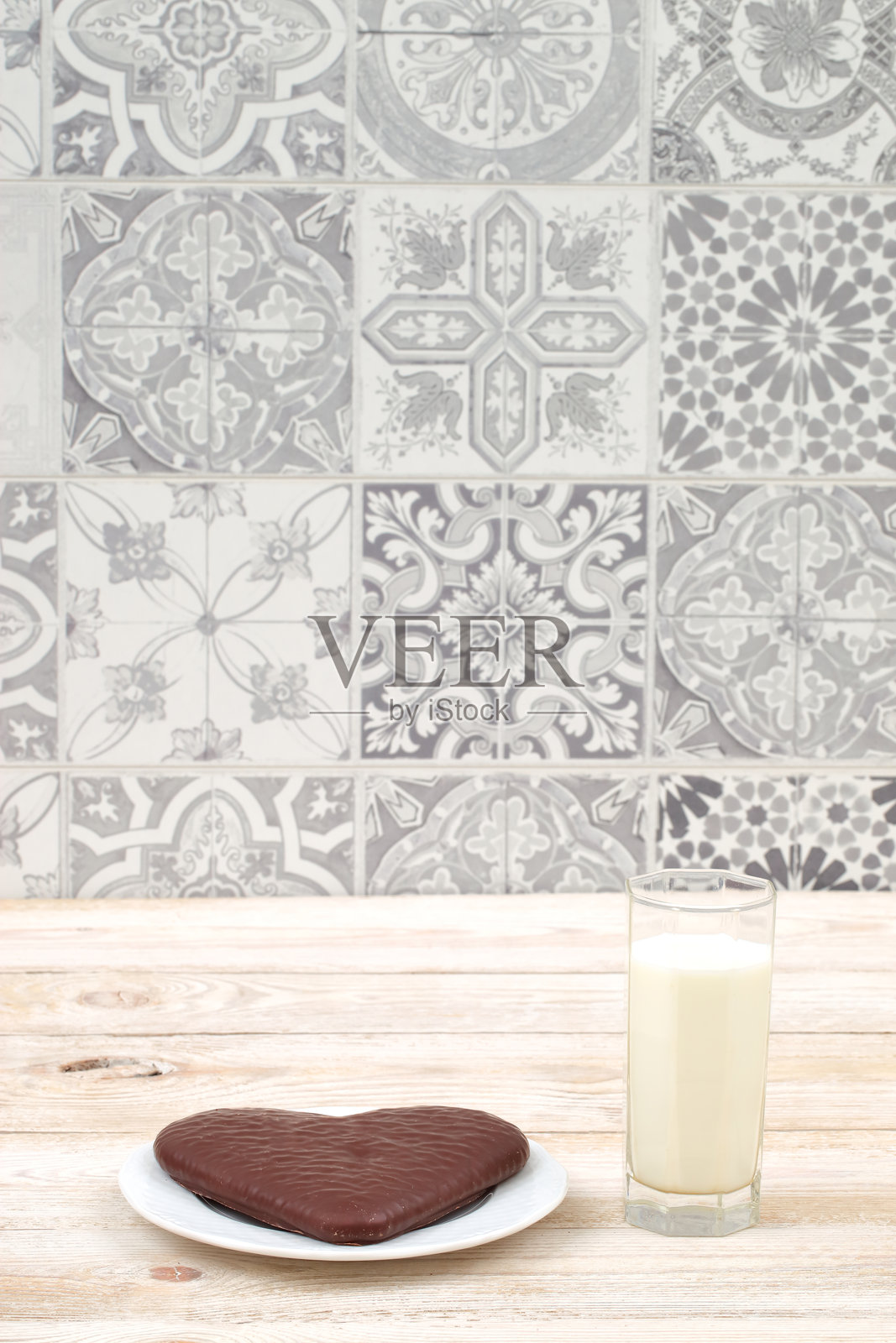 一款令人愉悦的心形巧克力蛋糕与牛奶搭配,摆放在乡村风格的桌子上照片摄影图片