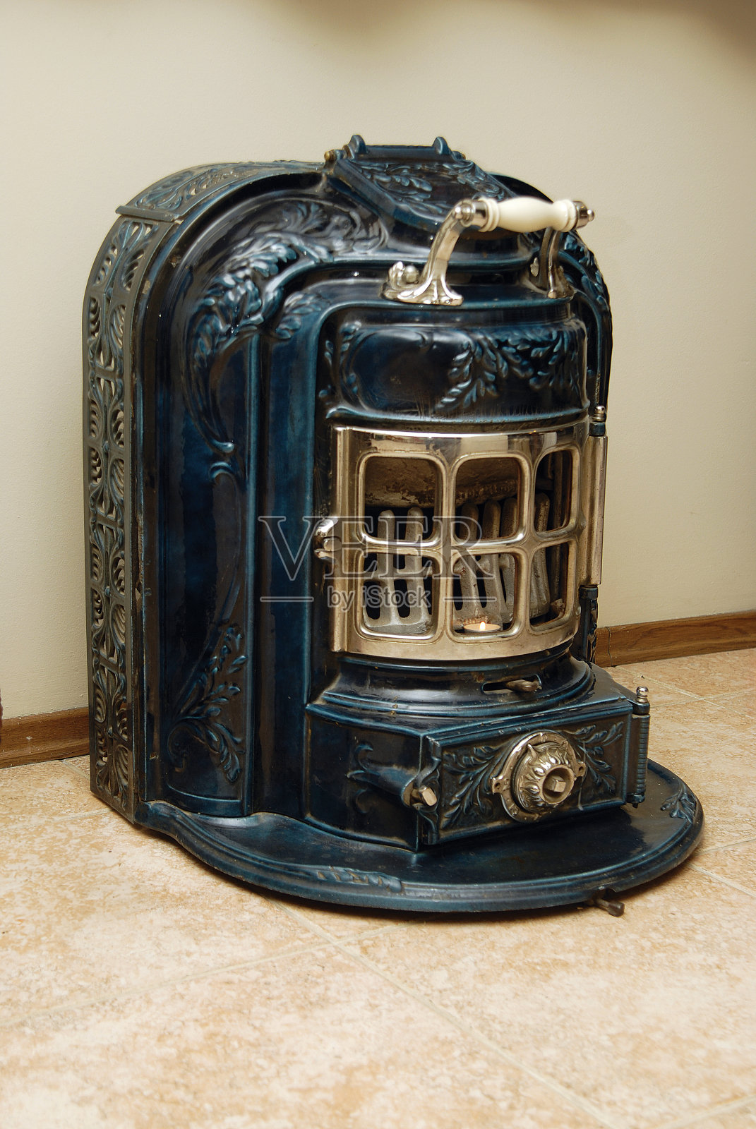 古董木炭炉,蓝色,金色前盖和白色陶瓷把手照片摄影图片