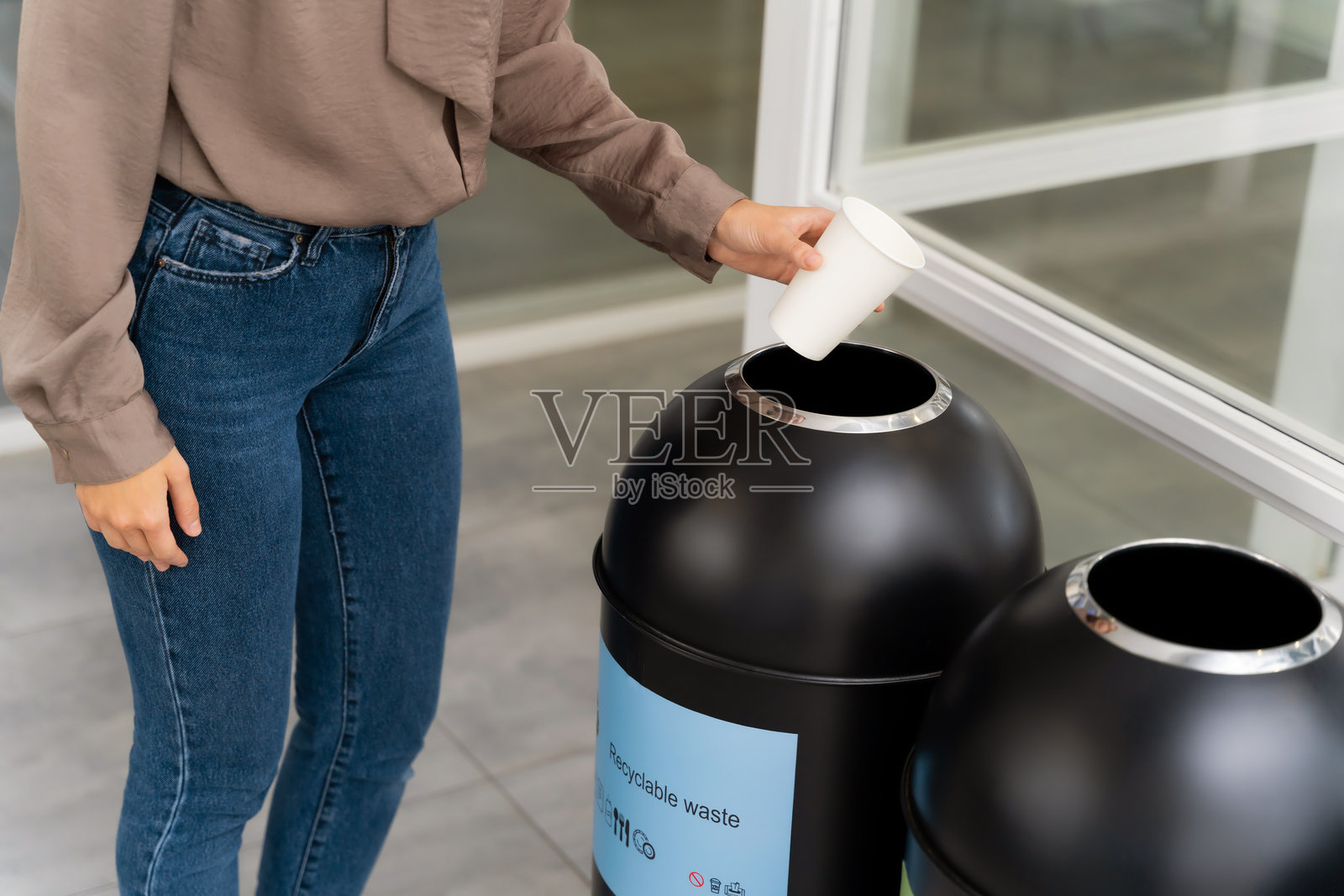 女性选择合适的容器来投放纸杯照片摄影图片