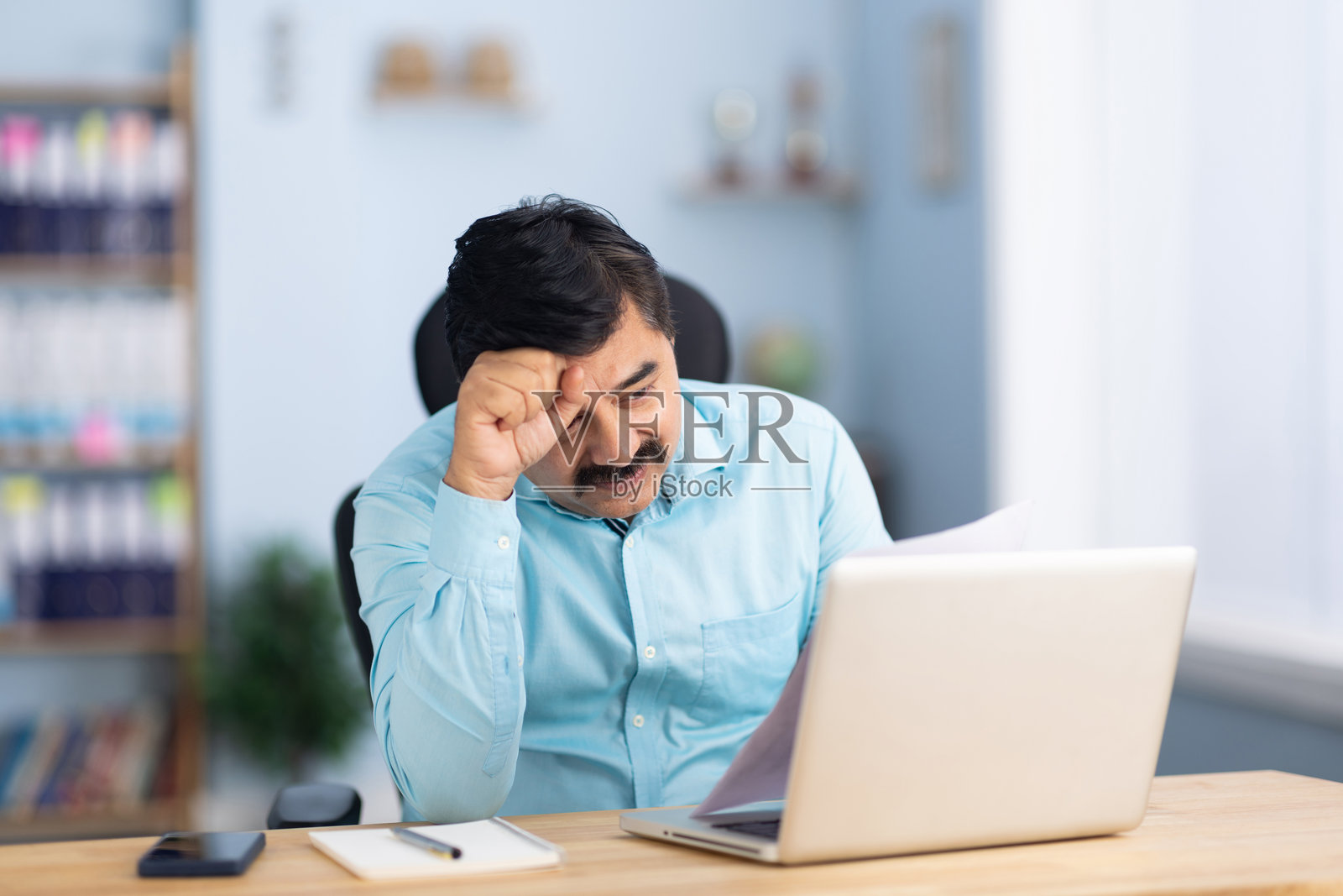 忧虑的商人在办公室坐着阅读分析文件照片摄影图片