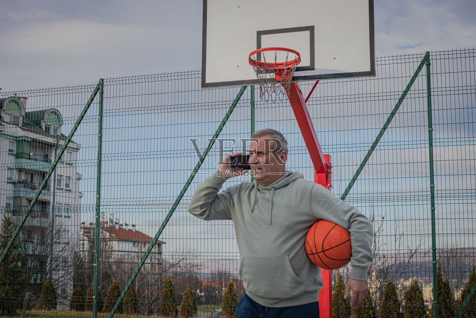 准备打篮球的老年男子正在使用智能手机照片摄影图片