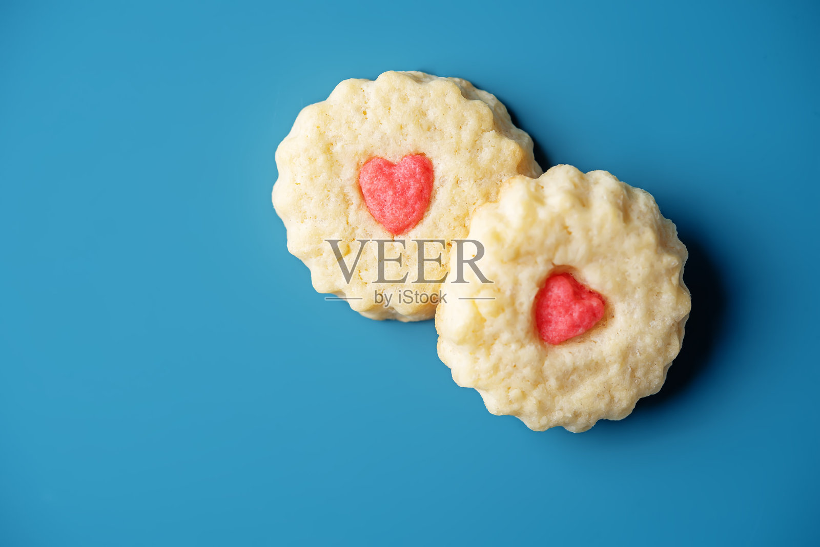 蓝色背景上的心形糖饼干,适合情人节假期照片摄影图片