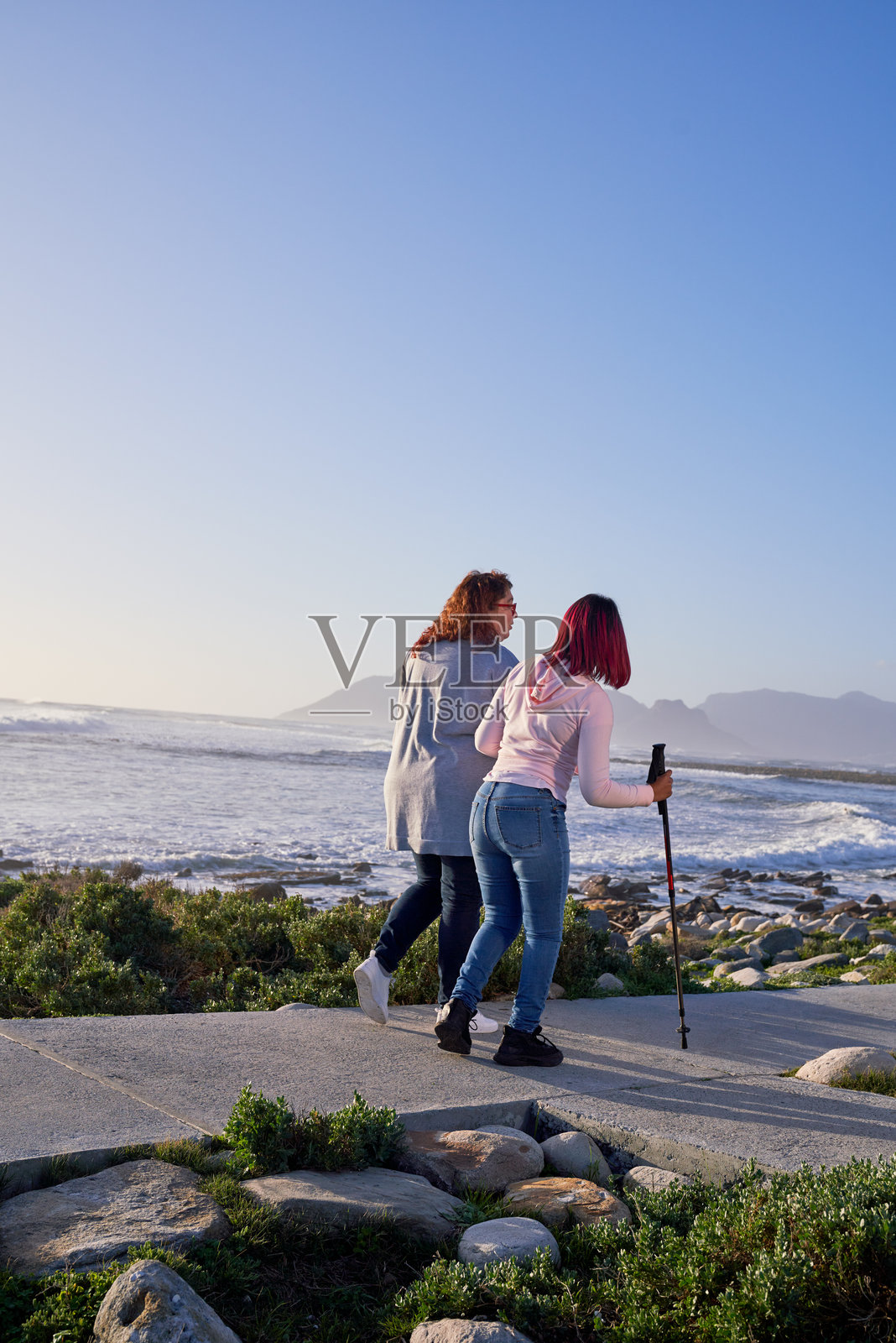 女性在海岸步道上散步照片摄影图片