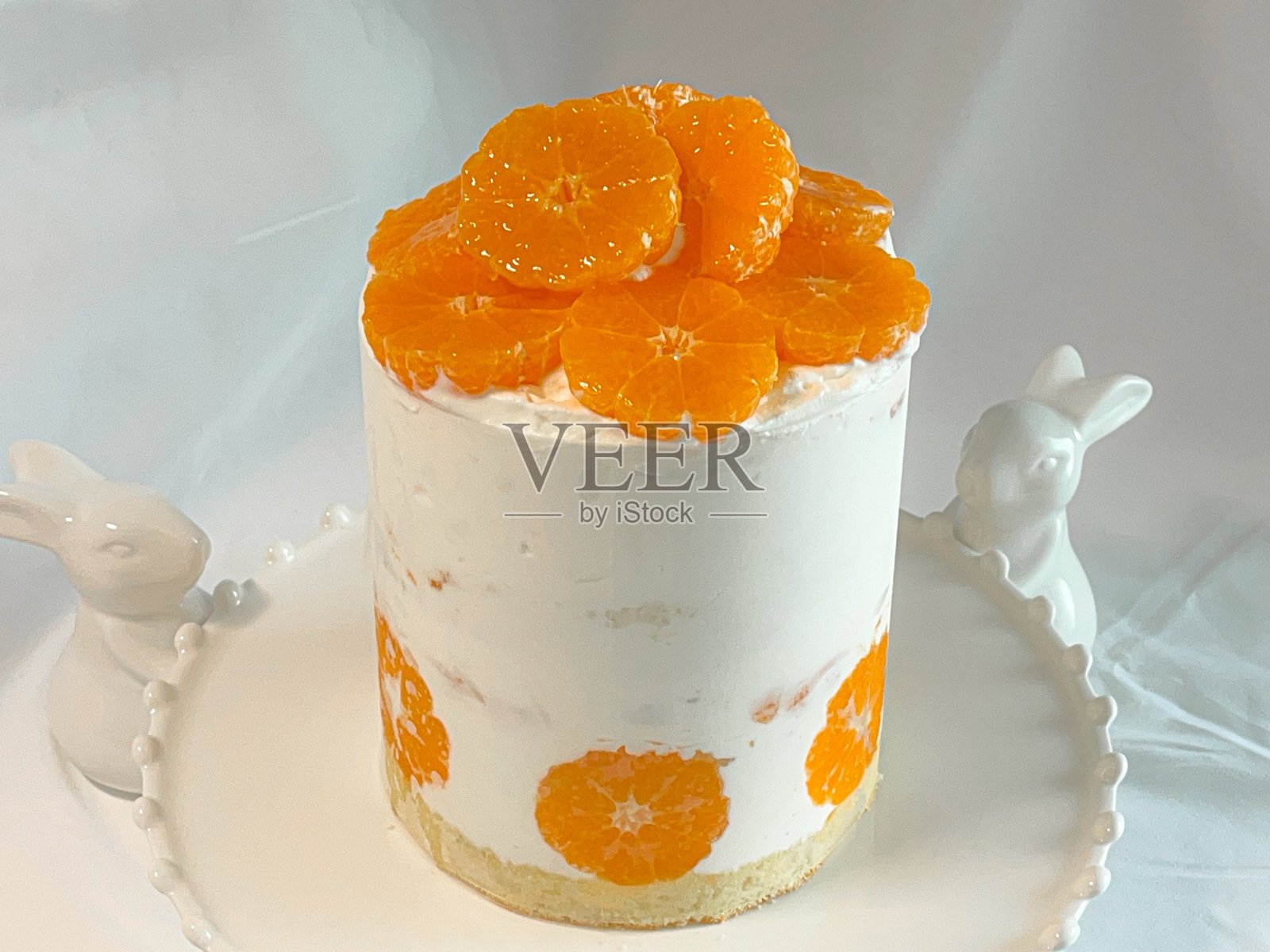 橙色海绵蛋糕,上面放有切片橙子,使用有机新鲜橙汁制作,包裹在锡纸中。照片摄影图片