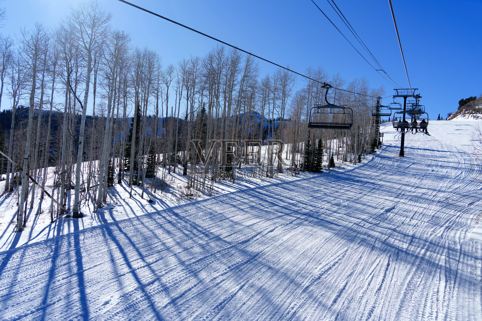 在阳光明媚的蓝天上,乘坐公园城的滑雪缆车照片摄影图片