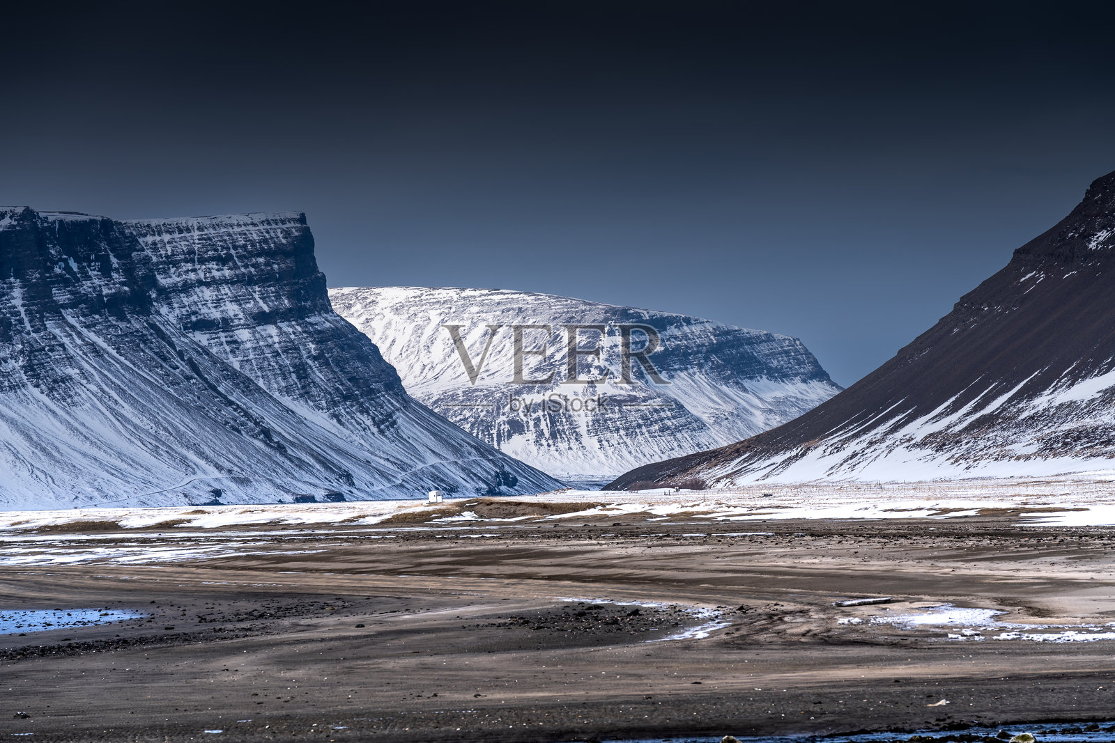 被雪覆盖的山脉与阴暗的天空照片摄影图片