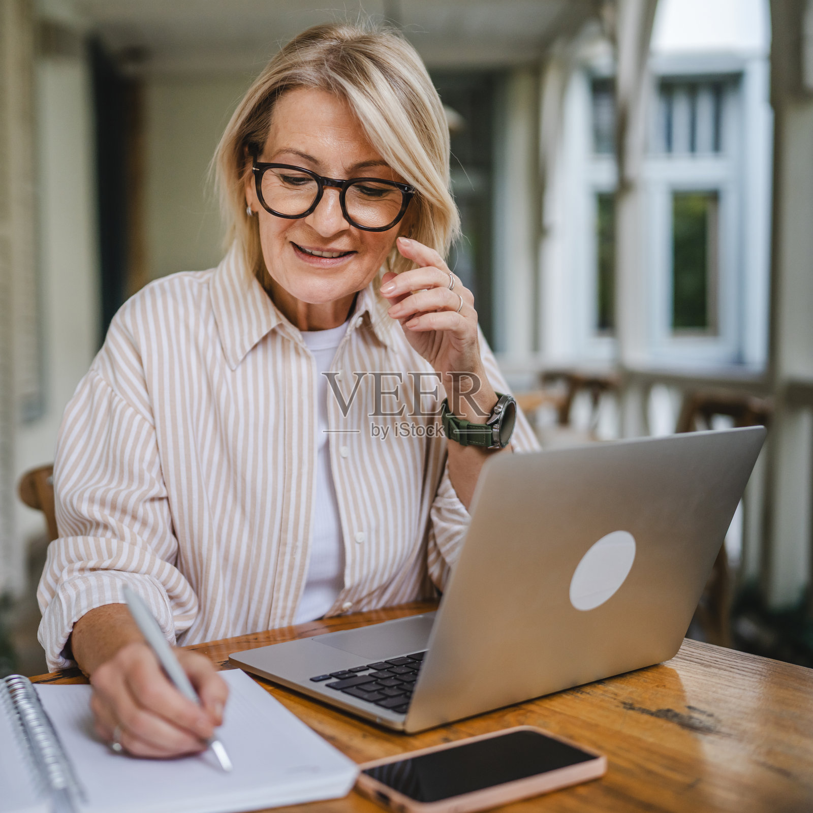 成熟的女性企业家在餐厅露台上使用笔记本电脑工作照片摄影图片