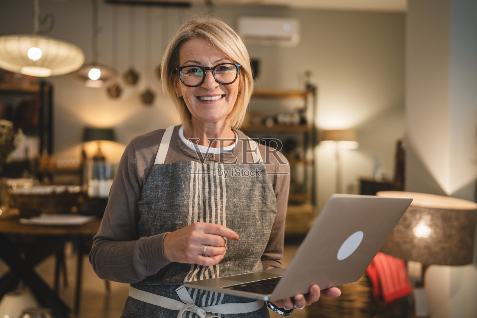 成熟的女性企业家在销售店使用笔记本电脑工作照片摄影图片