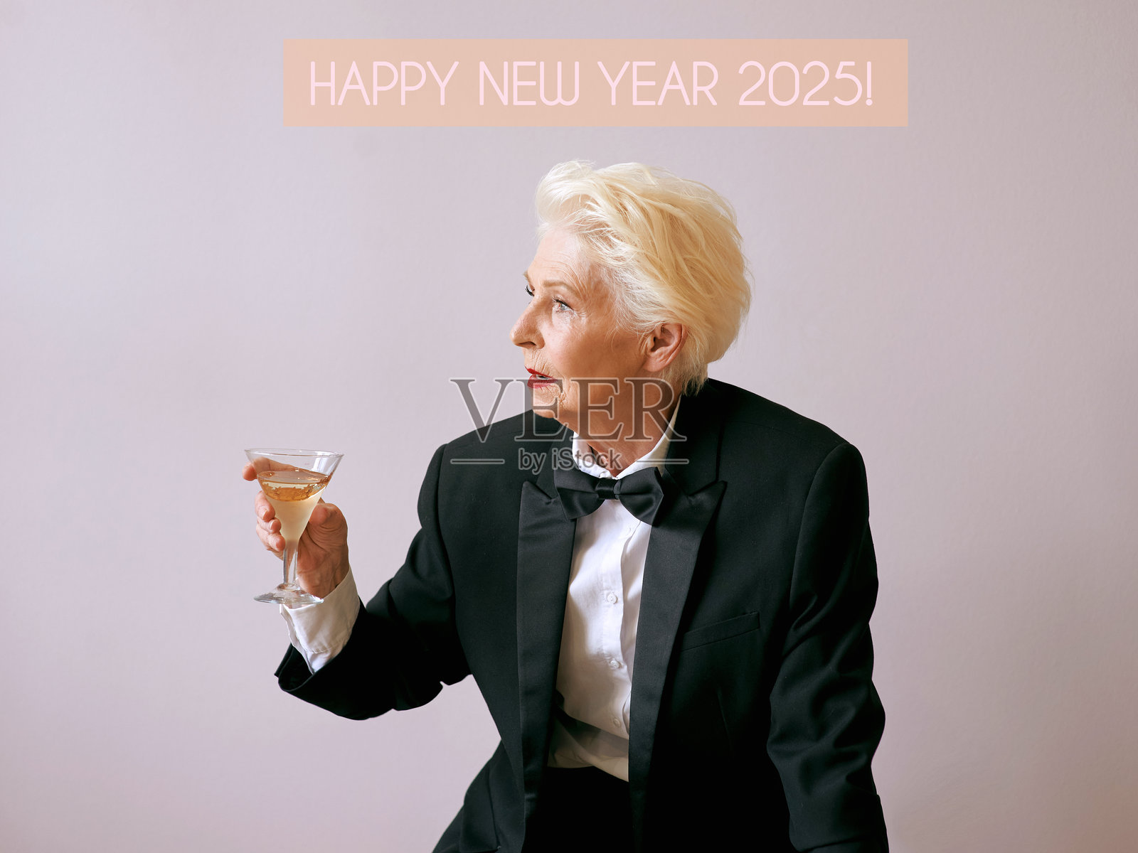 时尚的高级侍酒师女性身穿燕尾服,手持酒杯出席派对。饮品、成熟、风格、友谊概念照片摄影图片