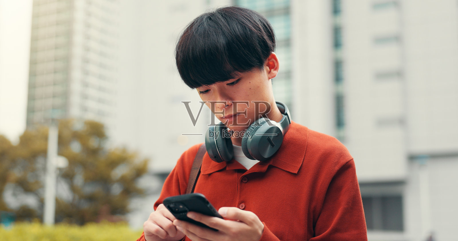 日本大学生在学生门户网站上使用手机进行在线流媒体和学习。社交媒体、网络和研究,户外的日本人与应用程序和聊天互动。照片摄影图片