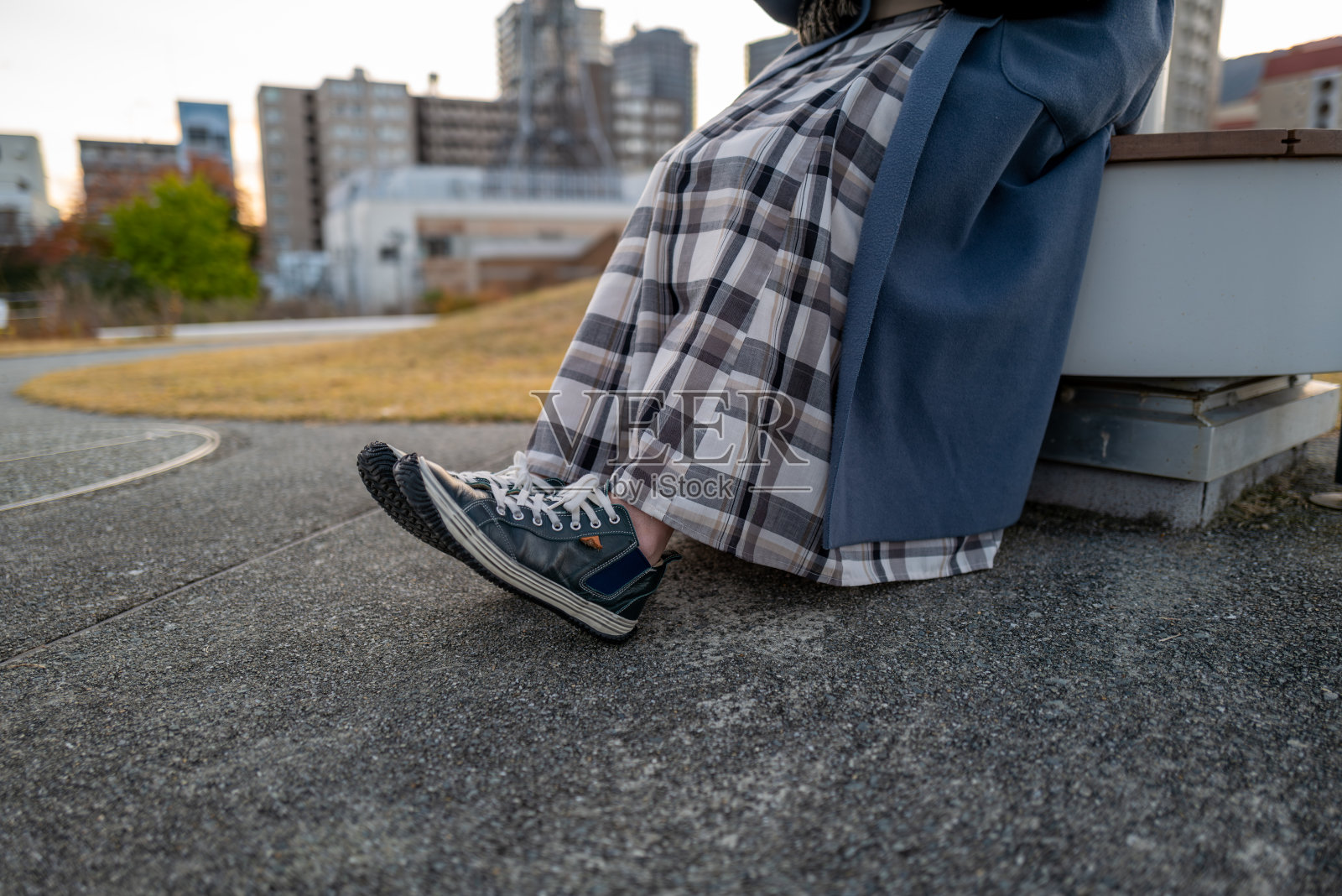 一位女性的双脚坐在公园长椅上照片摄影图片