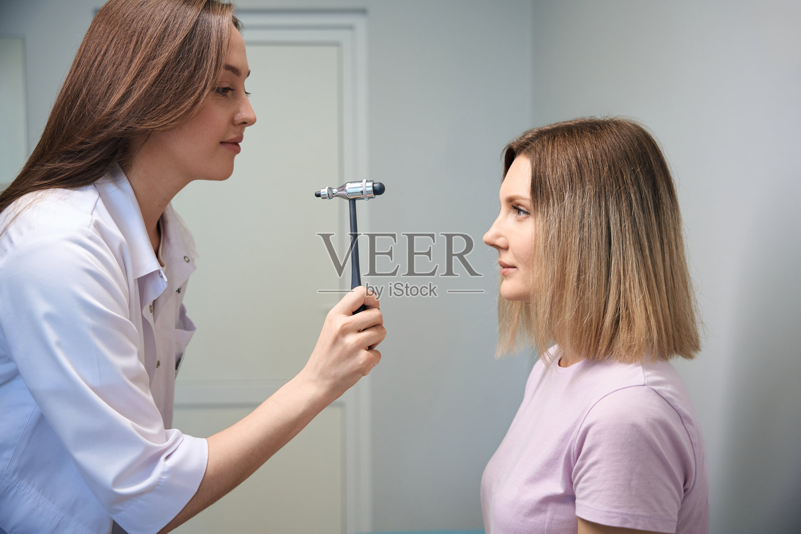 女性患者在神经科医生办公室观察锤子照片摄影图片