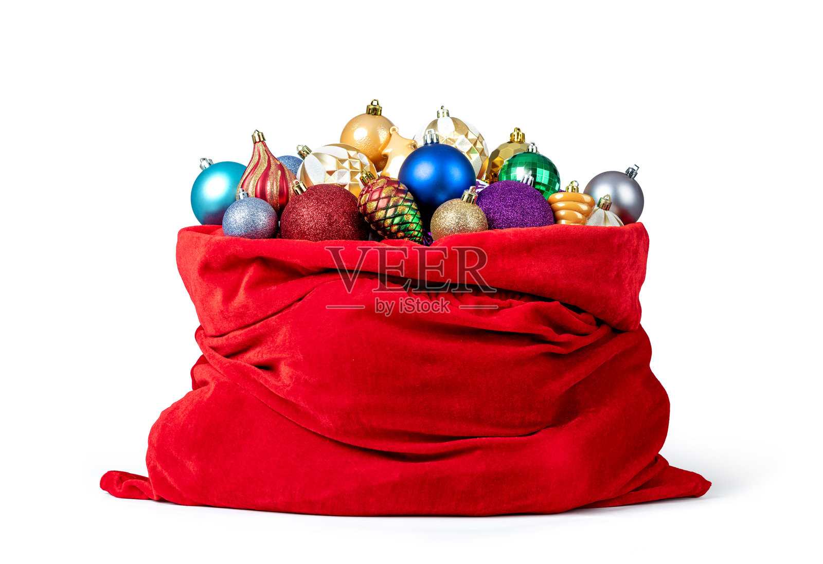 大红色圣诞老人包,里面装满了圣诞树玩具,背景为白色。文件包含隔离路径。照片摄影图片