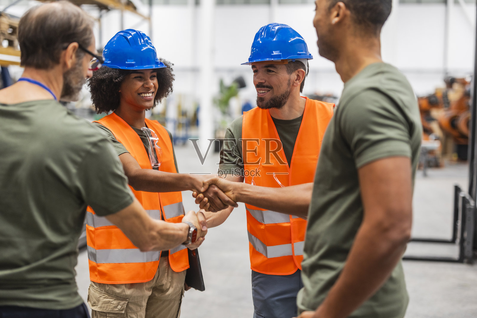 多种族工程师在现代工厂握手照片摄影图片