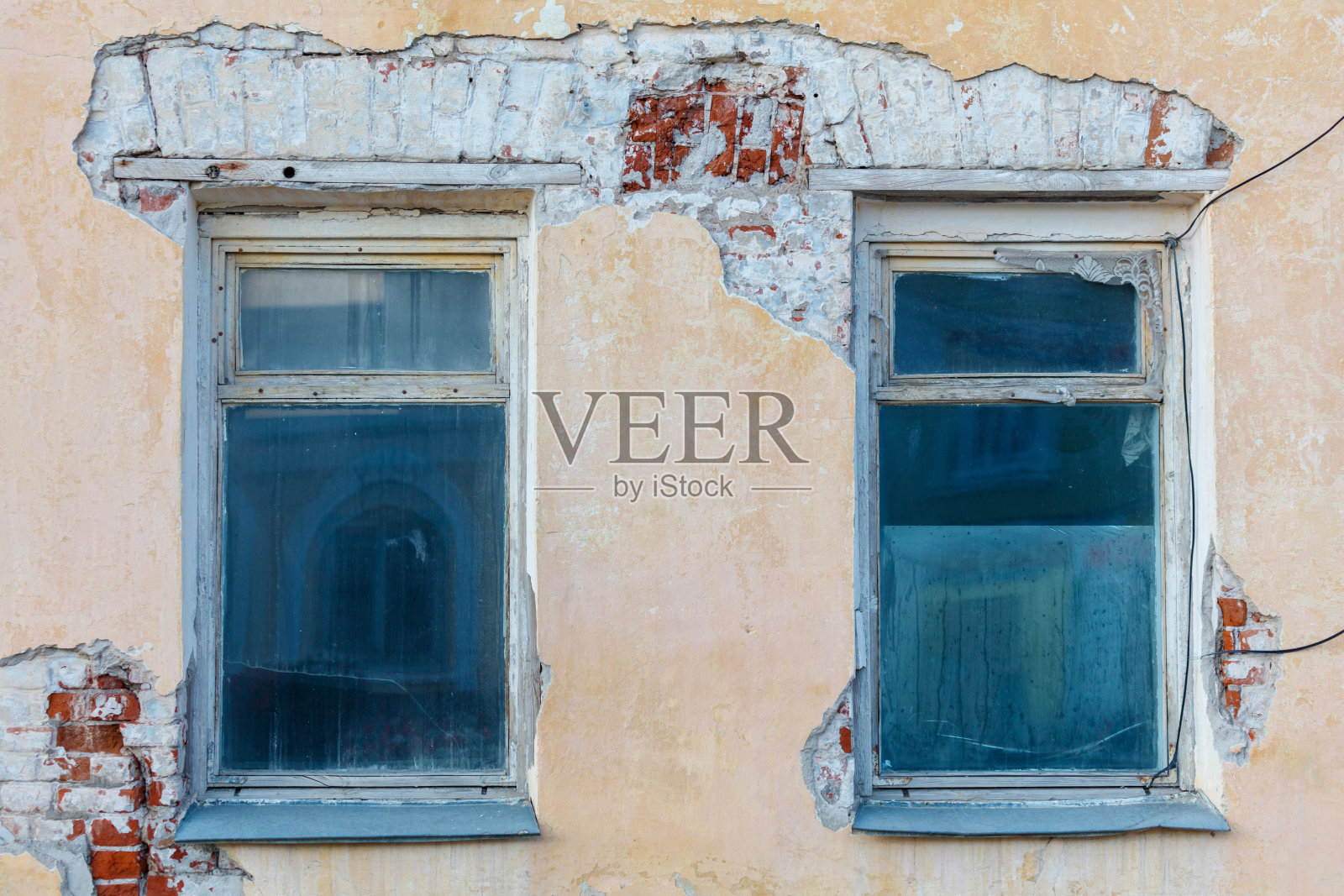 这两个窗户很脏,并且有很多裂缝。照片摄影图片