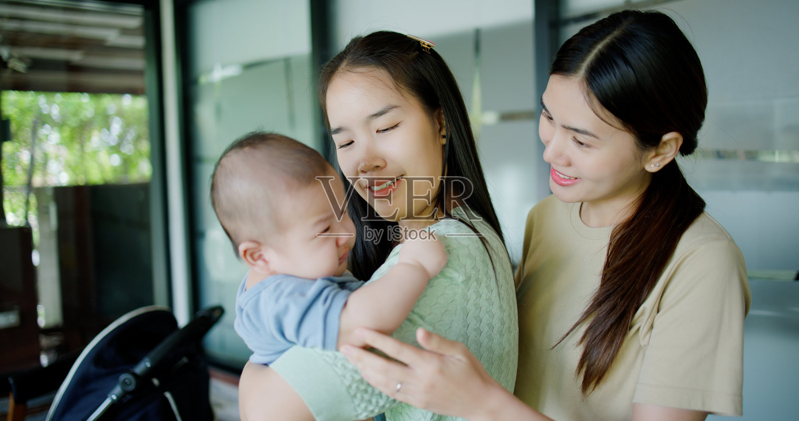 两位亚洲女性在咖啡馆安慰一个哭泣的男孩。照片摄影图片
