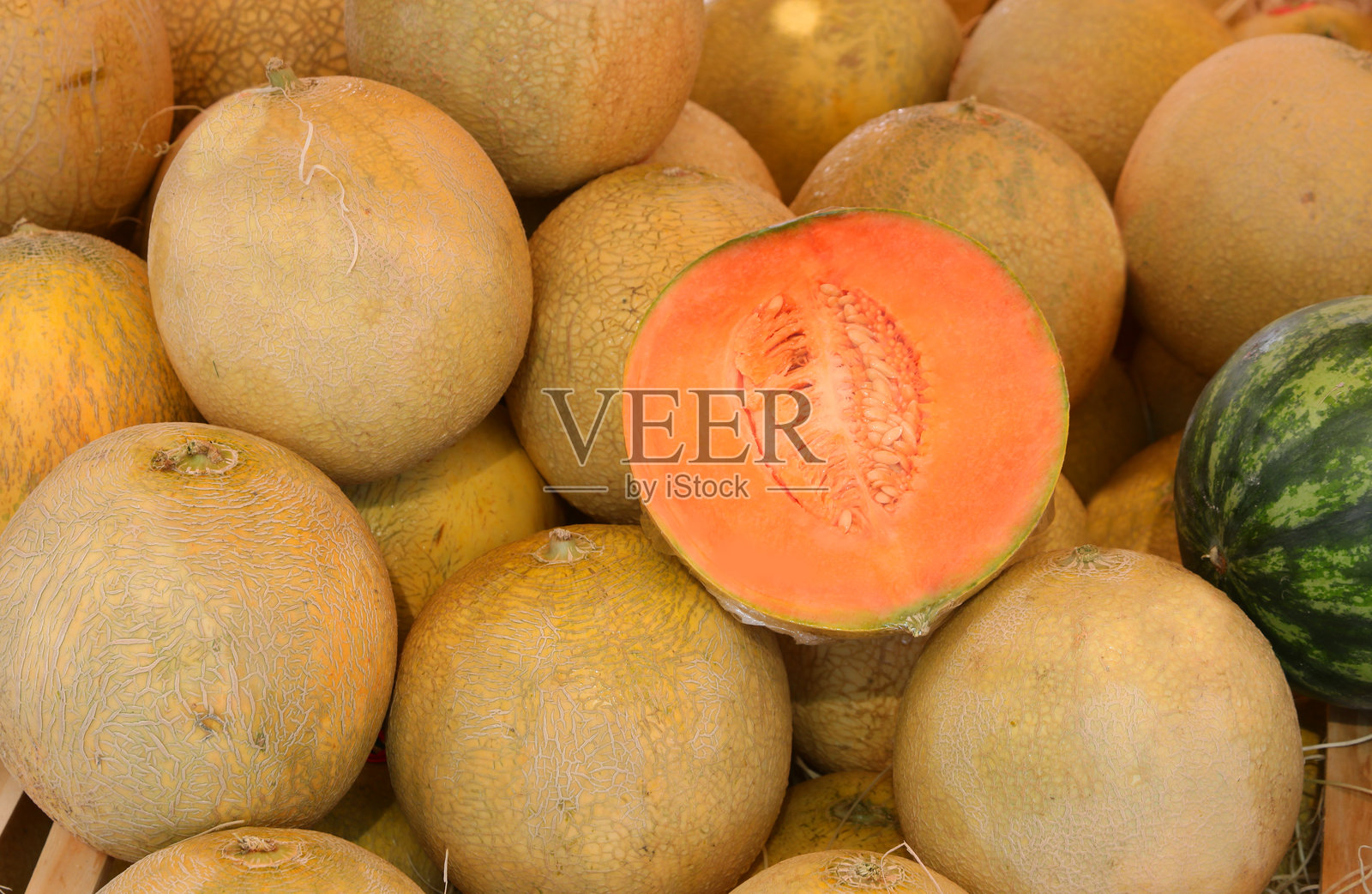 夏季当地市场水果摊位出售成熟的橙色蜜瓜照片摄影图片