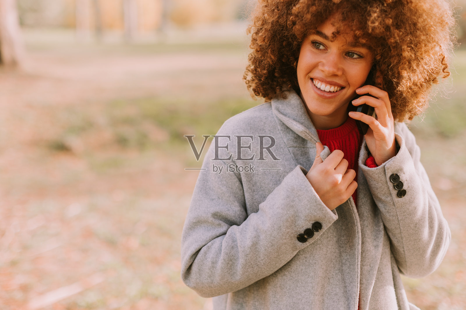 愉快的年轻女性在秋季宁静的户外环境中享受与手机的对话照片摄影图片