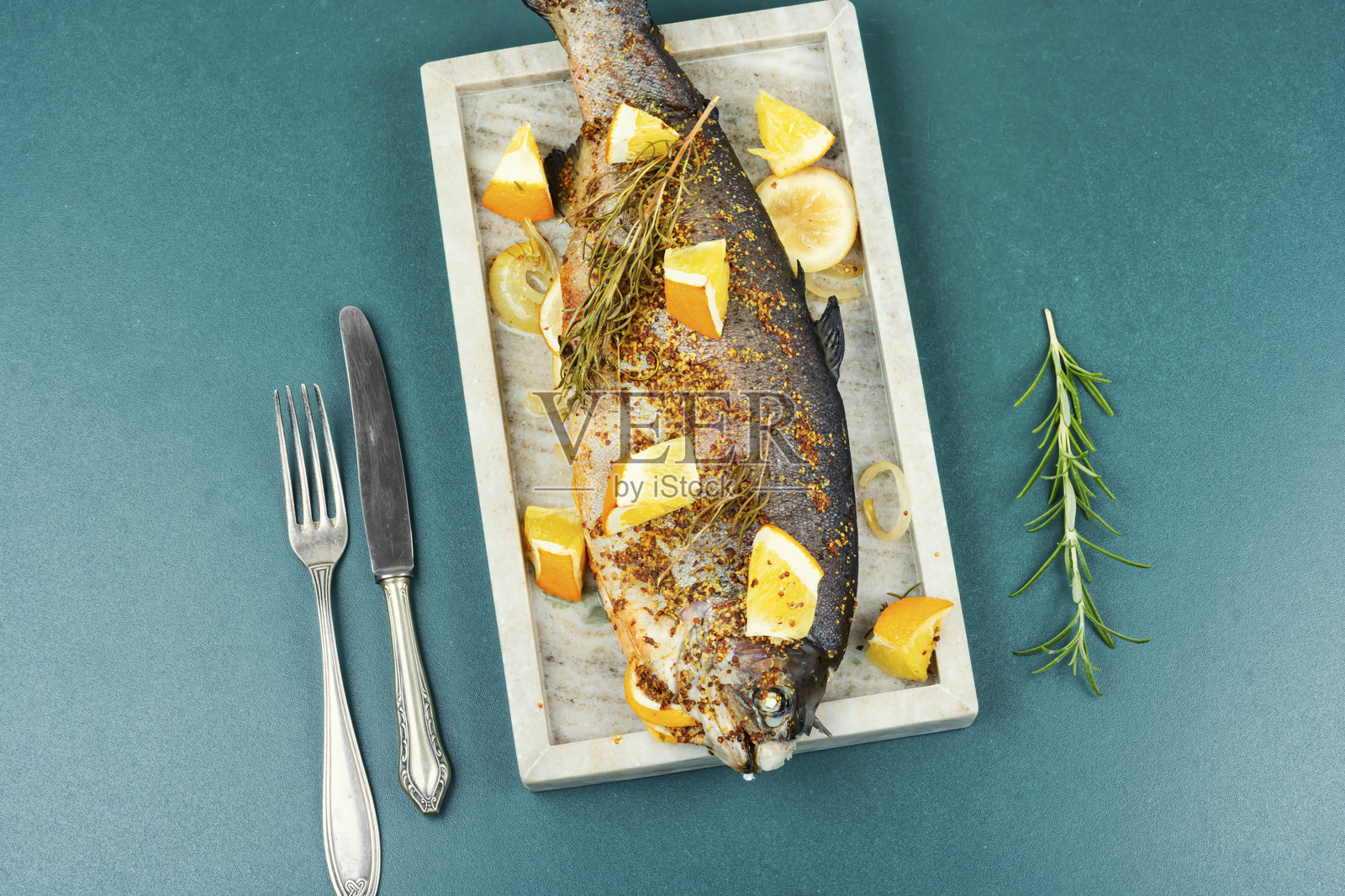 用羊皮纸烤制的彩虹鳟鱼。照片摄影图片