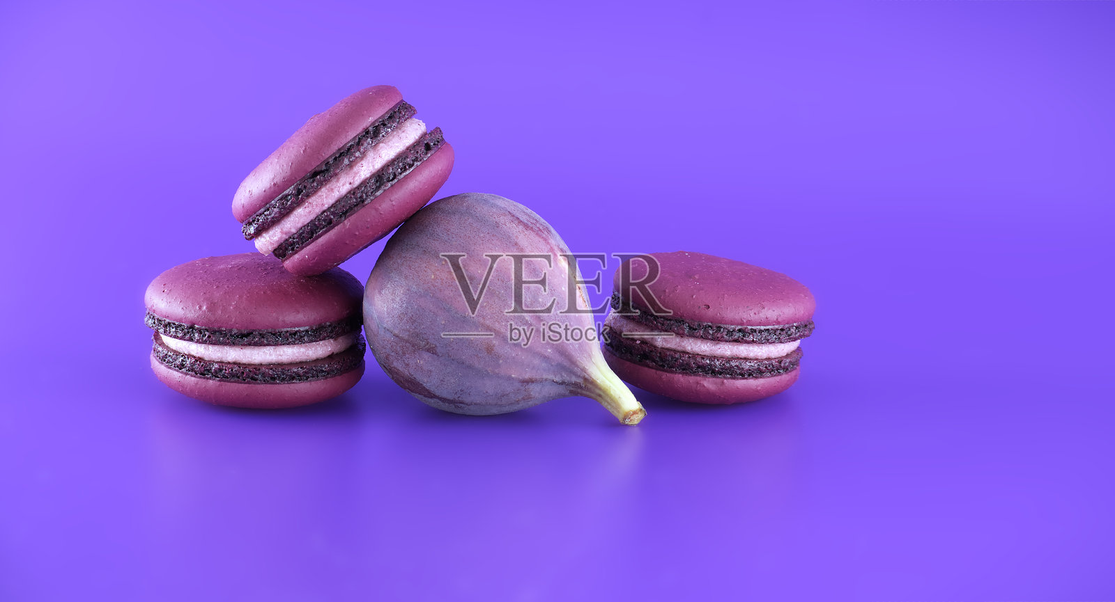 紫色背景上的马卡龙和水果照片摄影图片