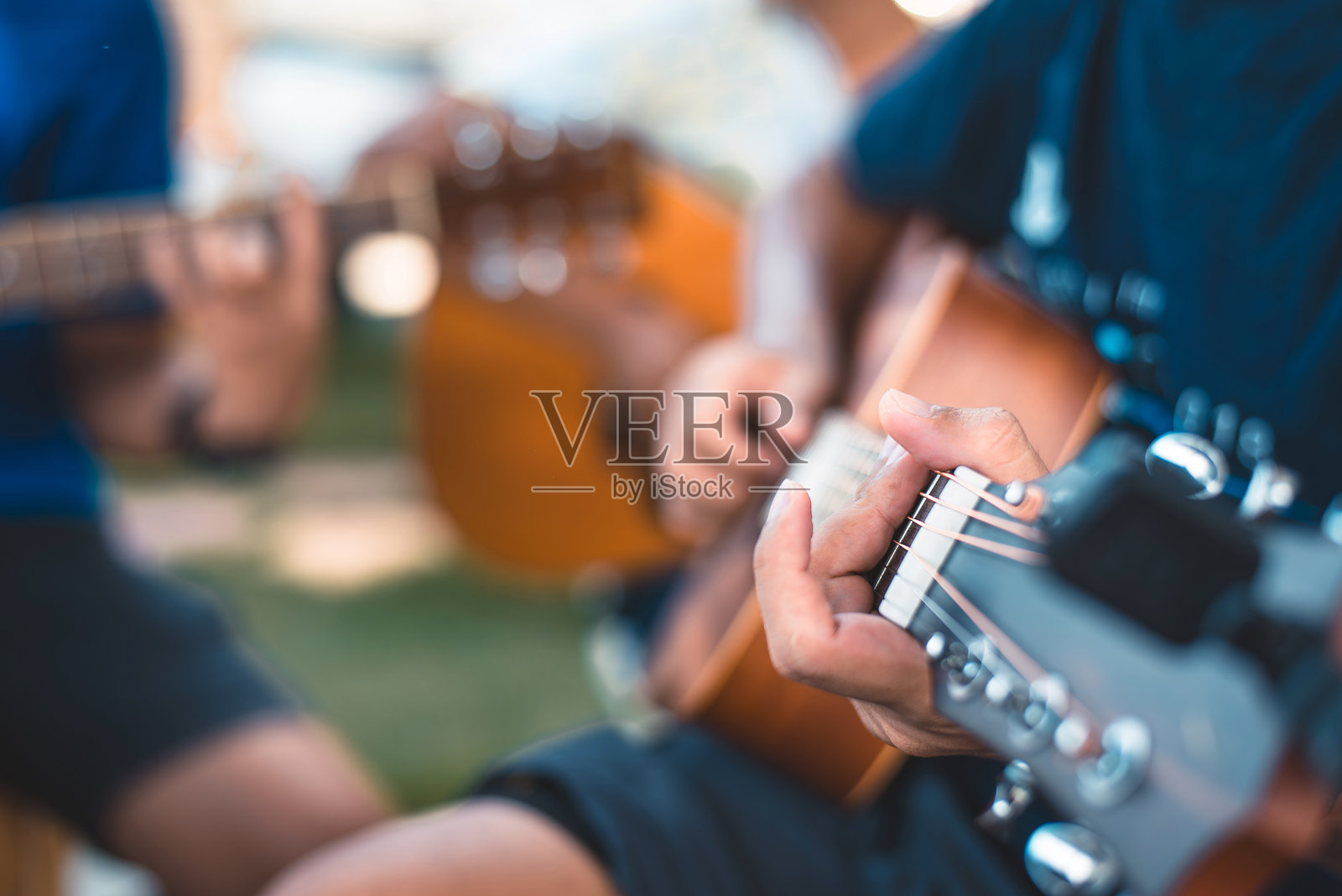 特写镜头下的手在弹奏木吉他照片摄影图片