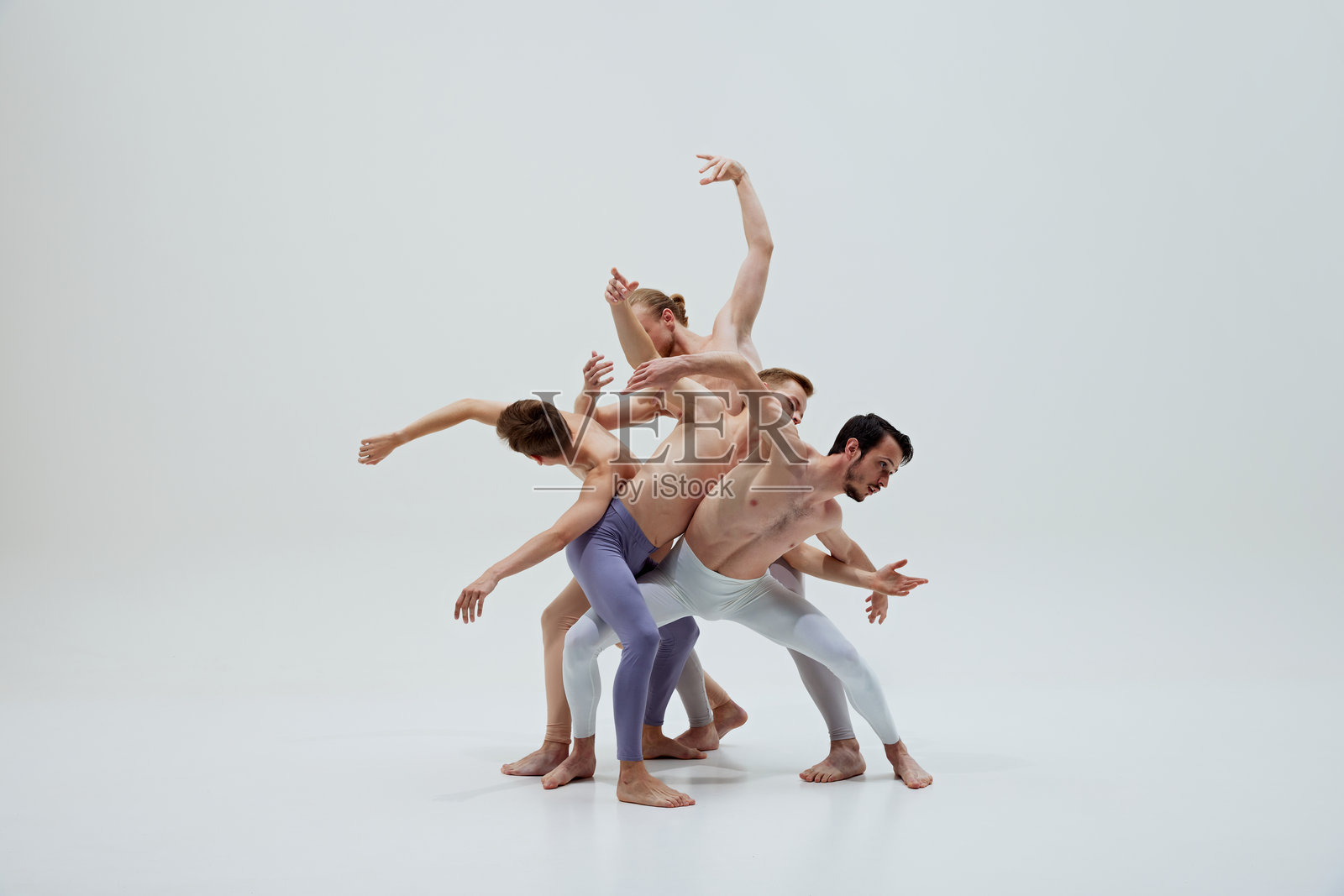 芭蕾舞者富有表现力和精准的动作在白色舞蹈室背景下凸显了他们的技巧和情感深度。照片摄影图片