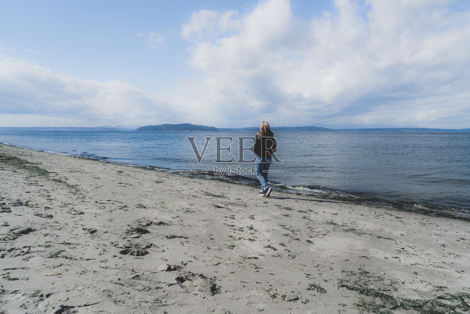 女人在海滩上散步照片摄影图片