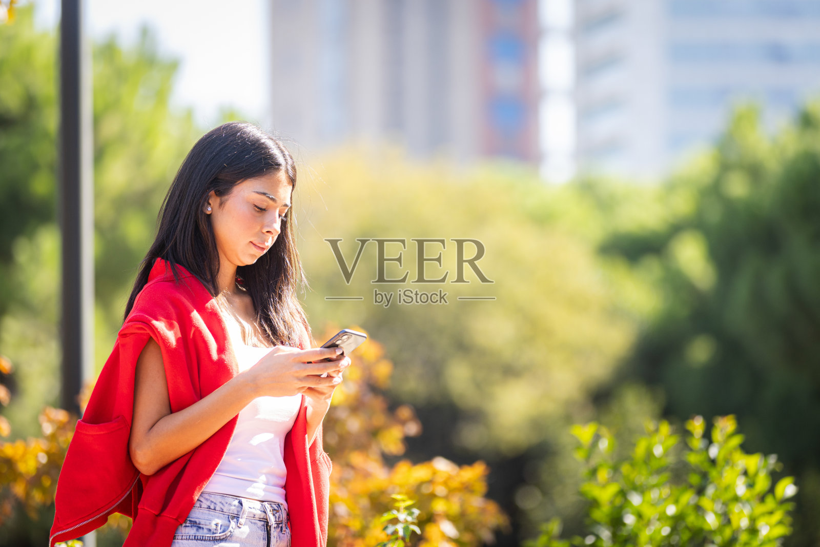 年轻女性在街上使用网上银行。照片摄影图片