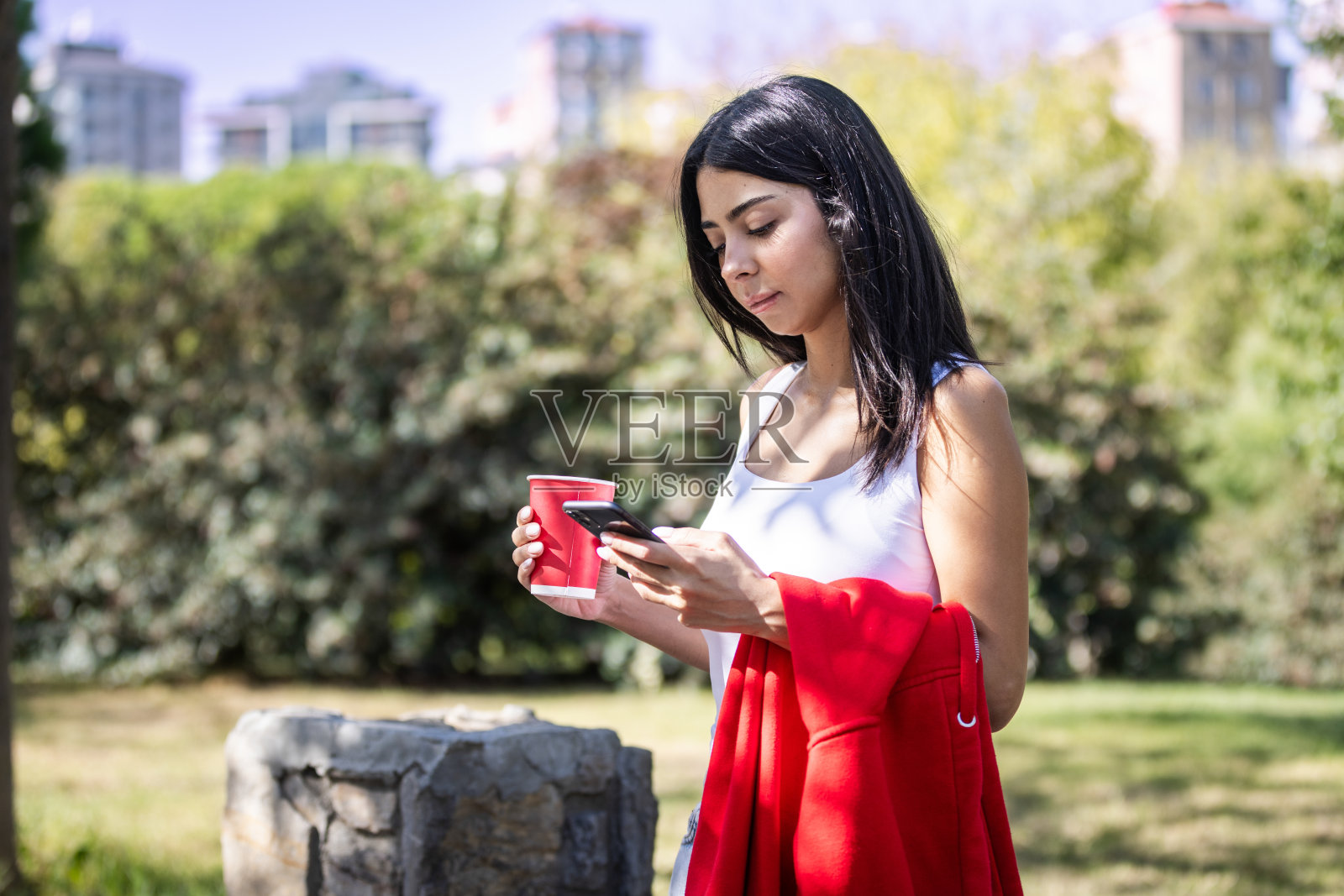 年轻女性正在手机上使用网上银行。照片摄影图片