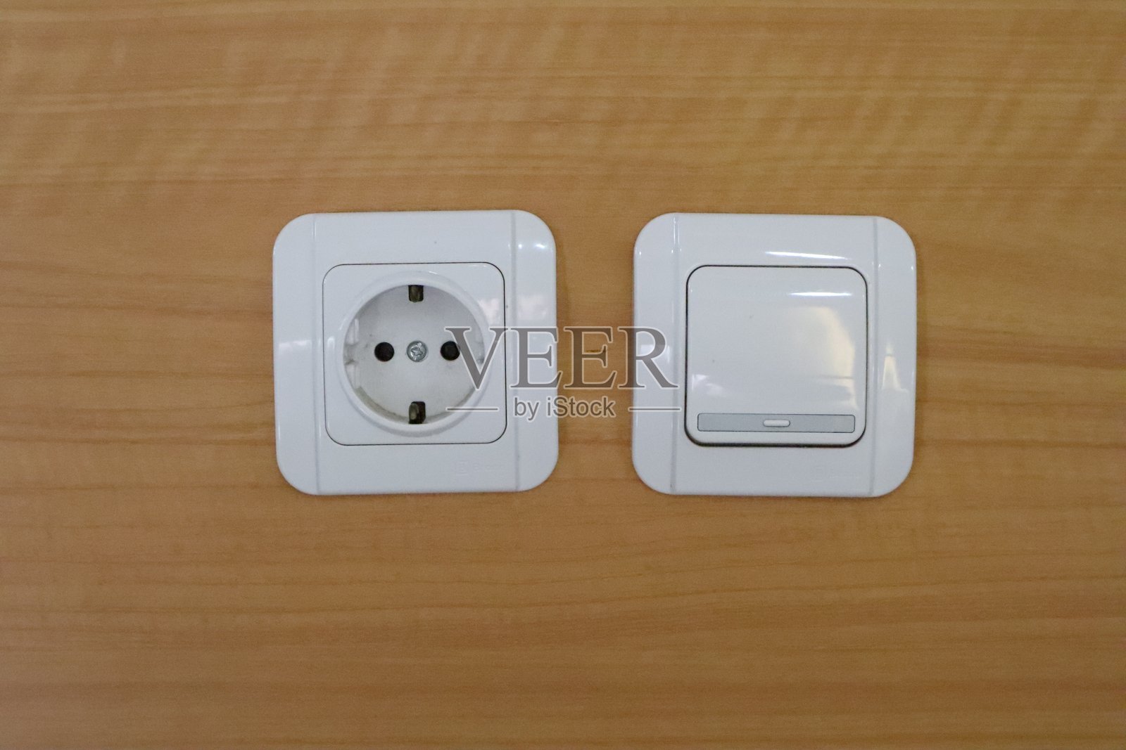 木纹墙上的双开关和电源插座照片摄影图片