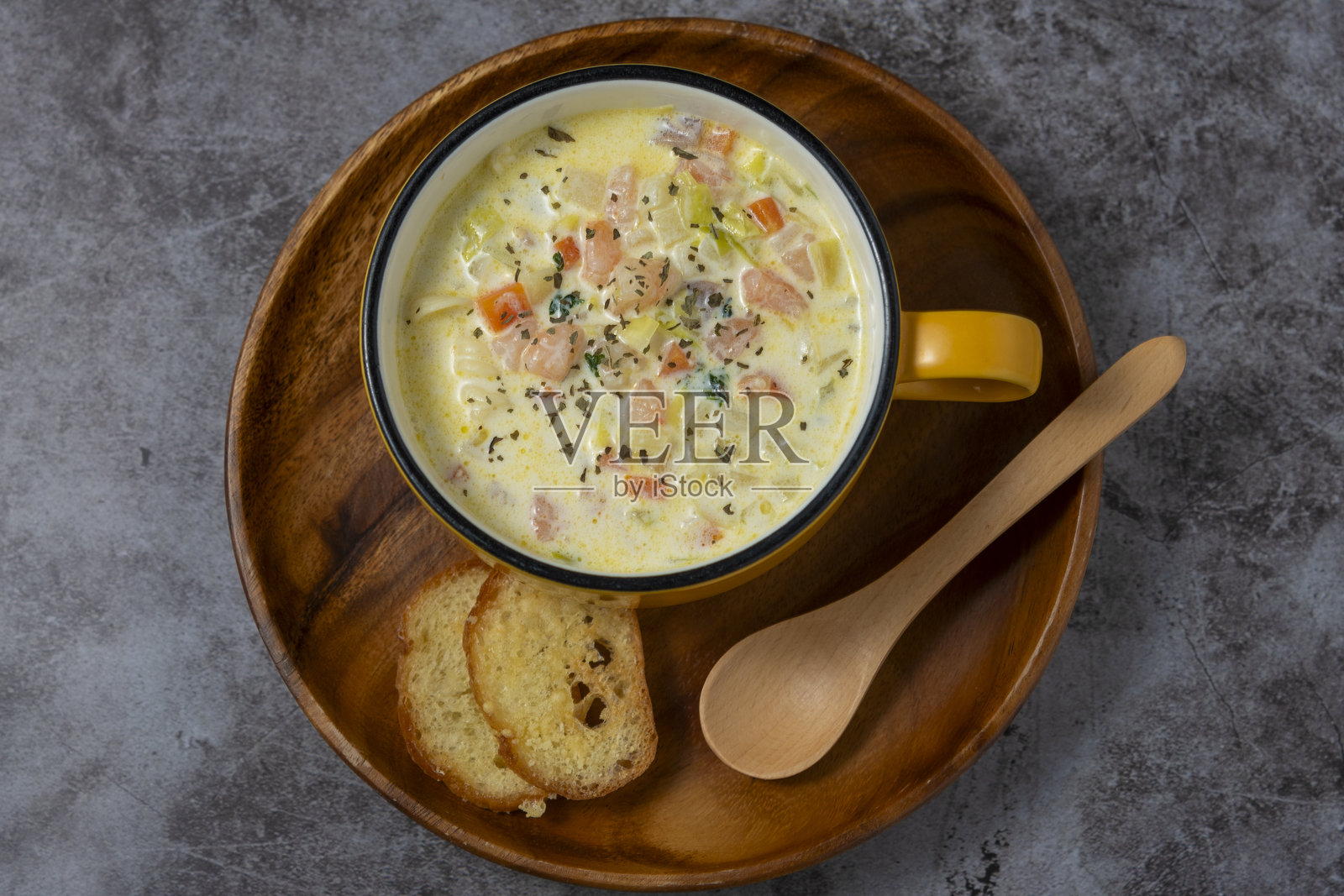 盘子上的杂烩汤和一把木勺照片摄影图片