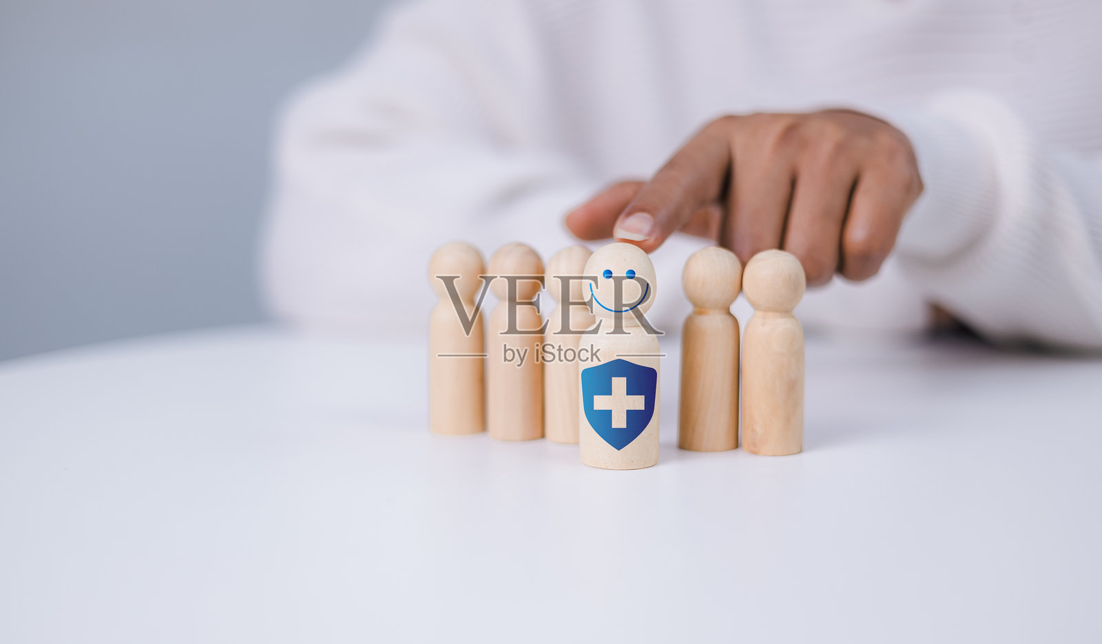 人手选择人寿保险并投资以降低风险。木偶与加号象征保护,获得利益。健康护理规划。保险和保护的概念。照片摄影图片