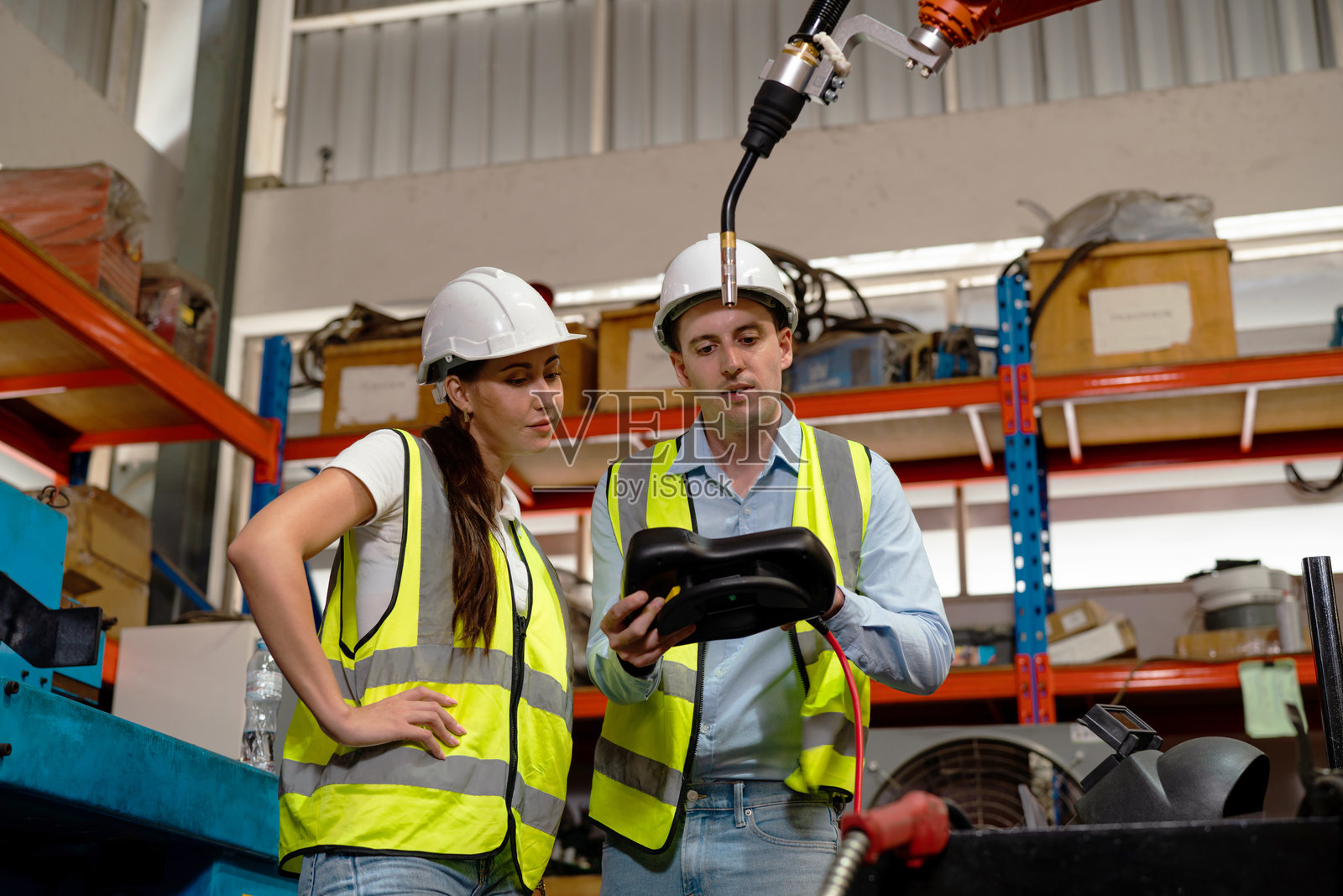 工程师使用带控制屏的强制焊接设备,该设备用于精密焊接控制。照片摄影图片