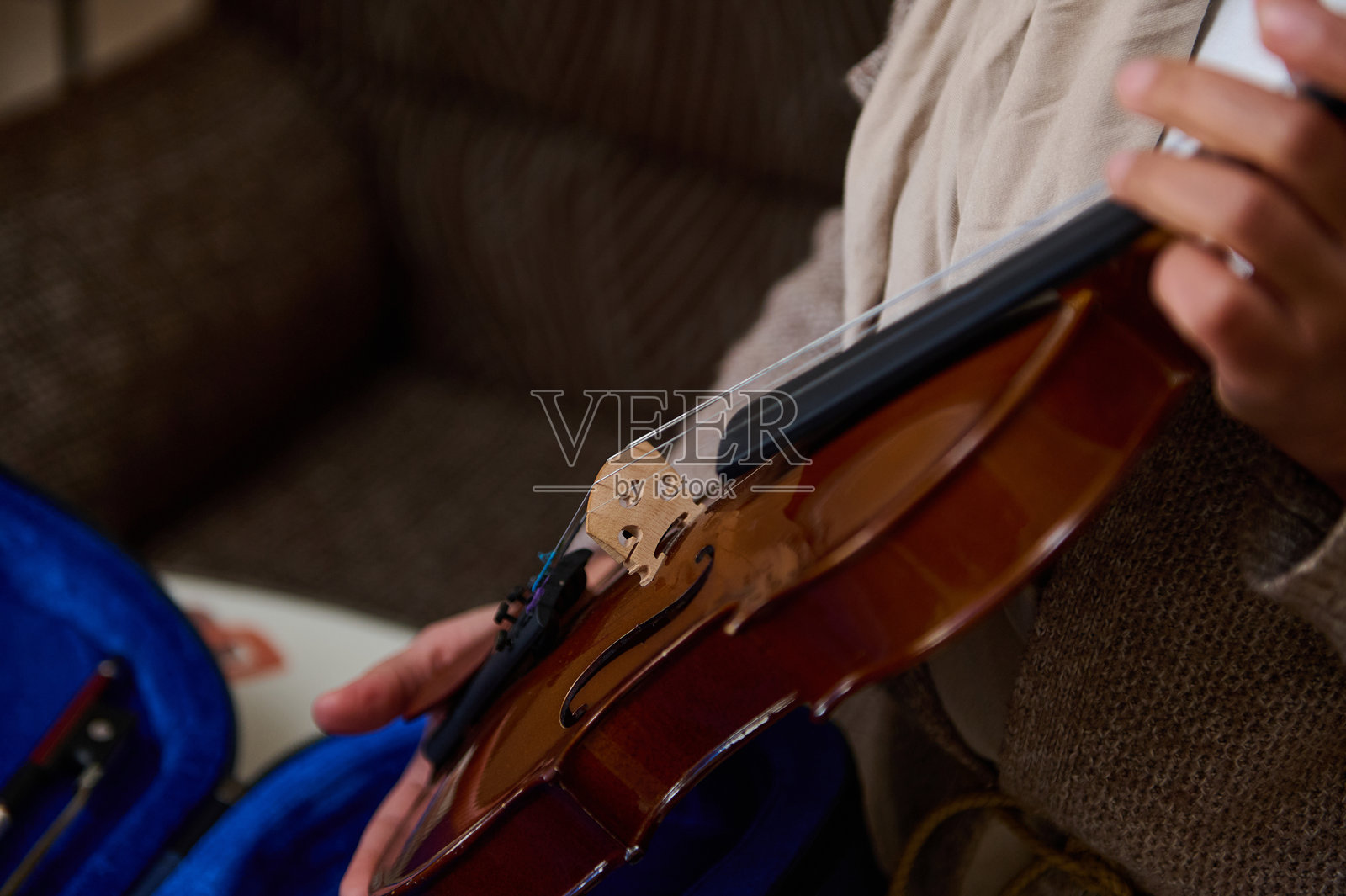 温馨环境中手握小提琴的特写镜头照片摄影图片
