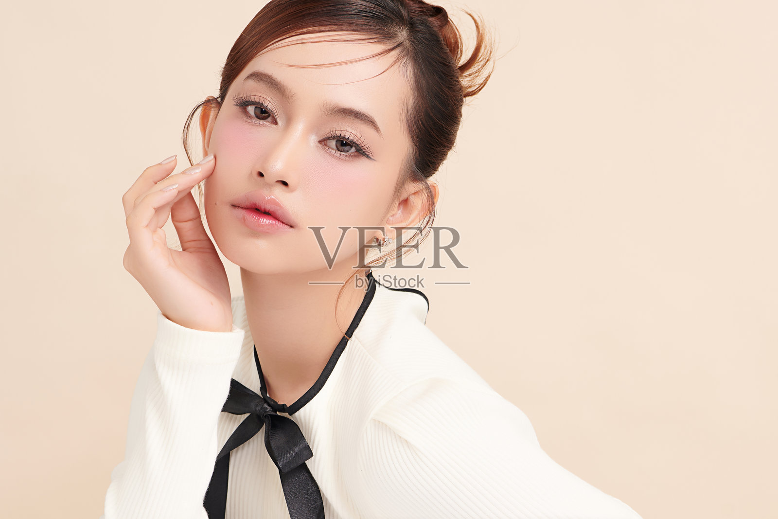 美丽的年轻亚洲女性,肤色洁净清新,背景为米色,面部护理,面部治疗,美容学,美容与水疗,亚洲女性肖像。照片摄影图片