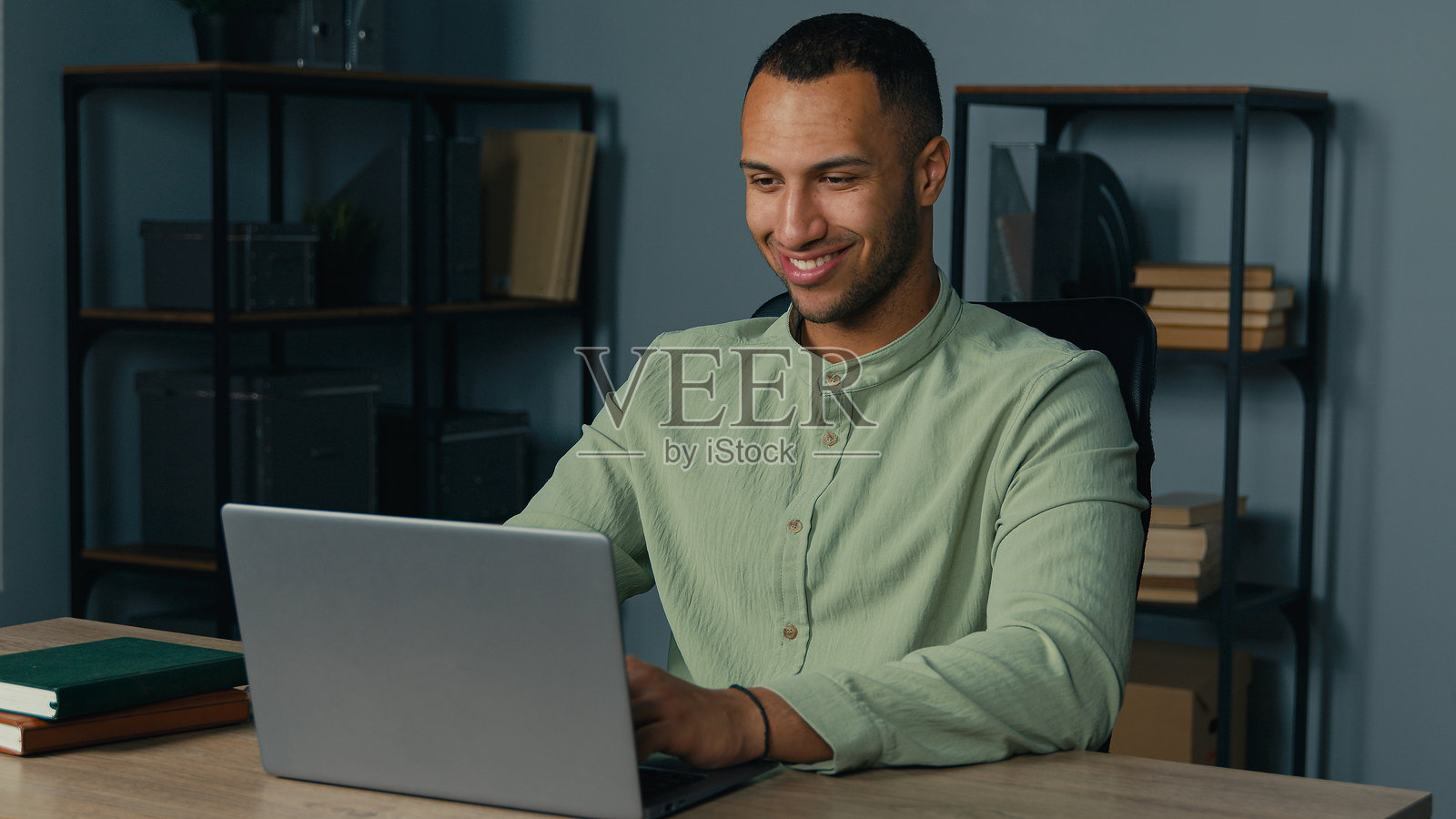 兴奋快乐的非裔美国男商人赢家在办公室查看电子邮件,阅读笔记本电脑上的好消息,庆祝商业成功,在线胜利,获得职业发展新机会和工作邀请。照片摄影图片