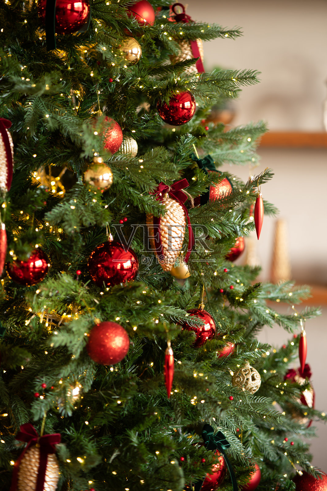 装饰着红色球、金色松果和天鹅绒蝴蝶结的圣诞树。照片摄影图片