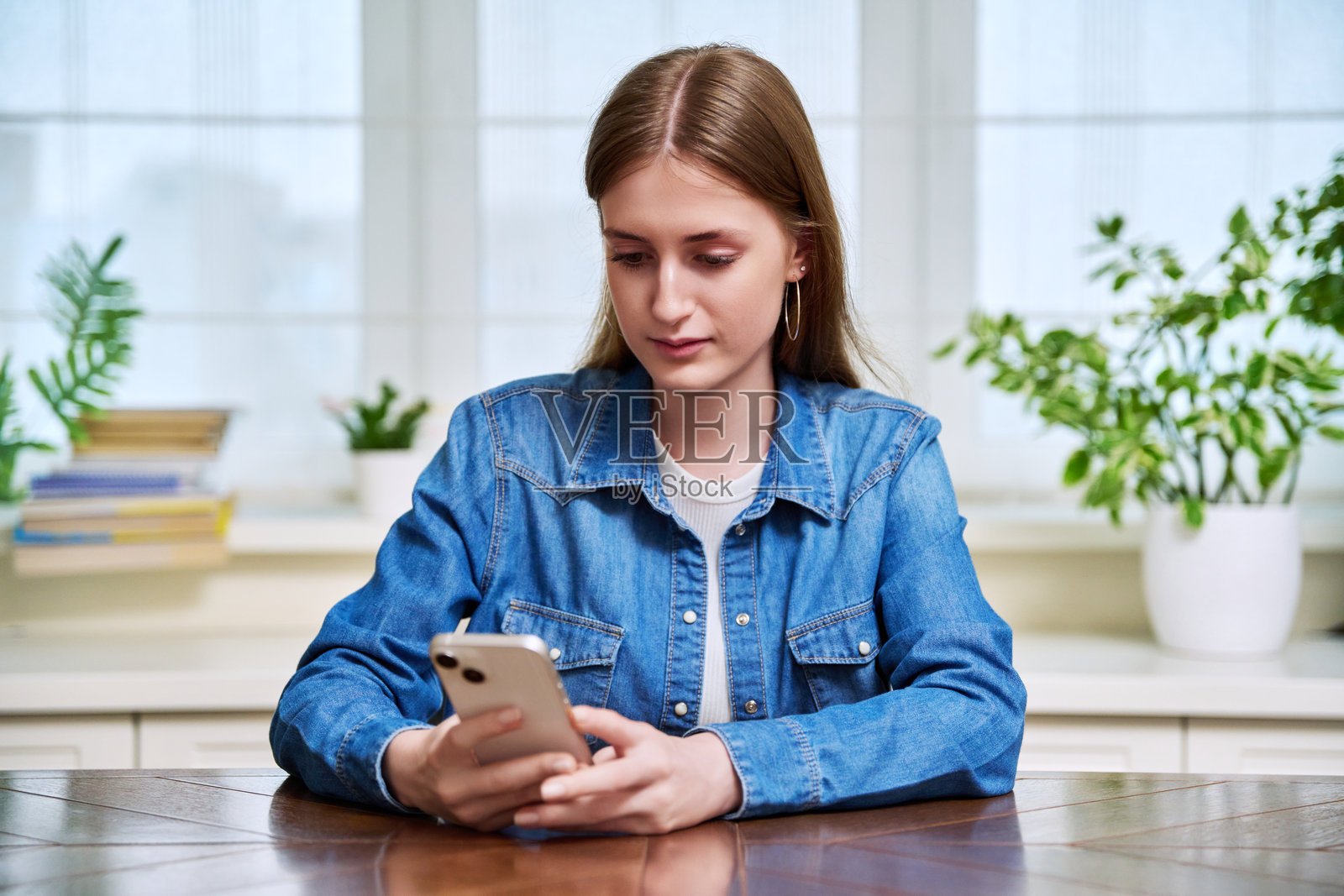 严肃的女青少年在家中使用智能手机照片摄影图片