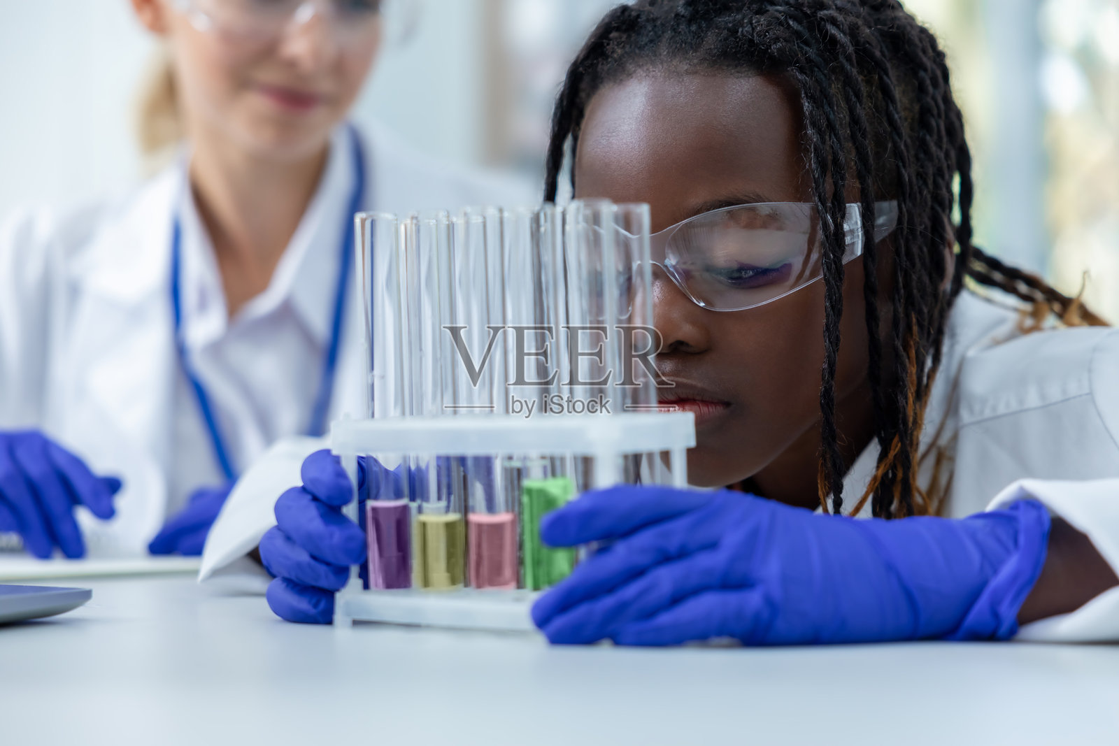 女性专业人员在诊所中使用试管进行病毒样本实验照片摄影图片