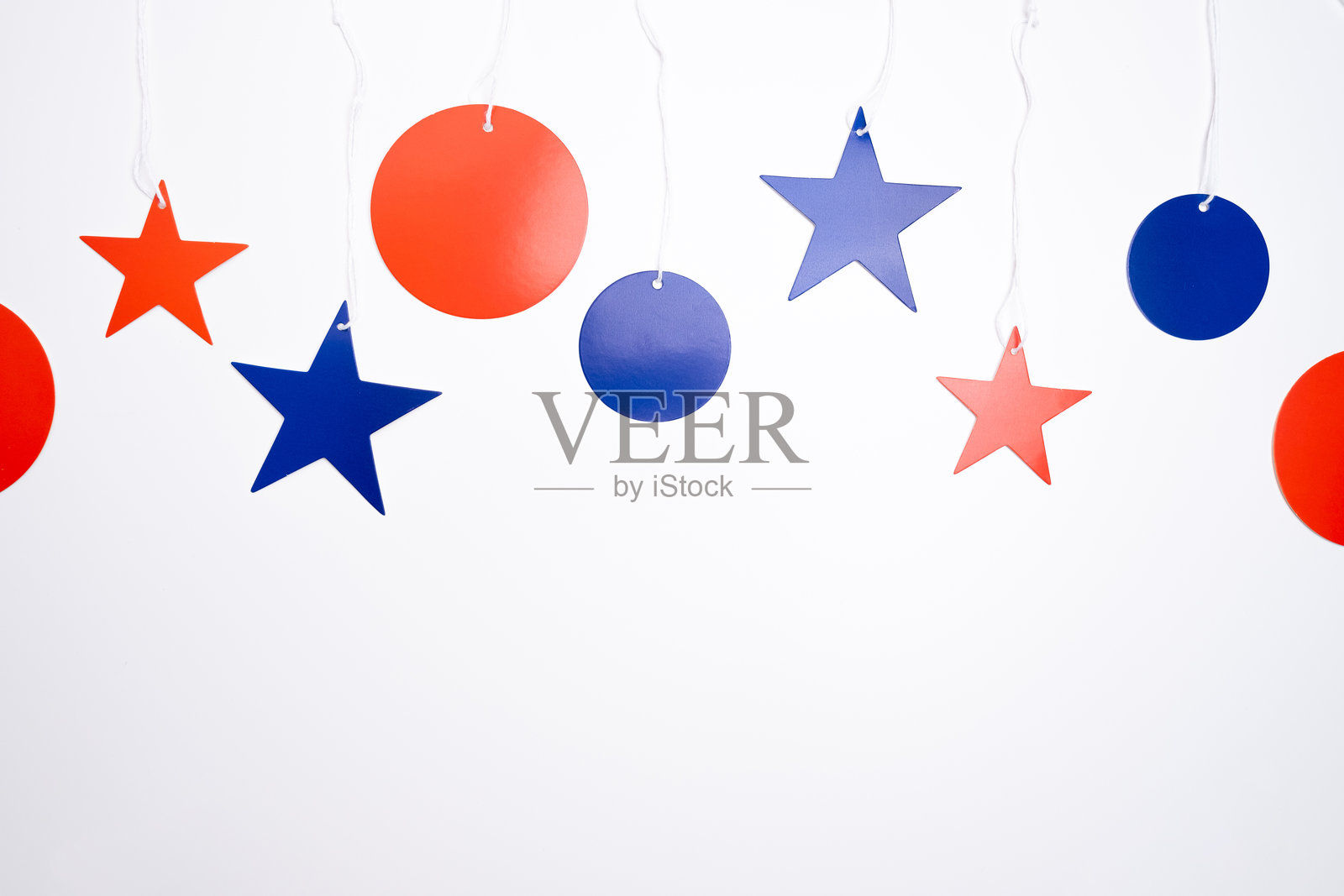 浅色背景上的红蓝星星装饰。留白,极简风格,适合设计的节日背景。照片摄影图片