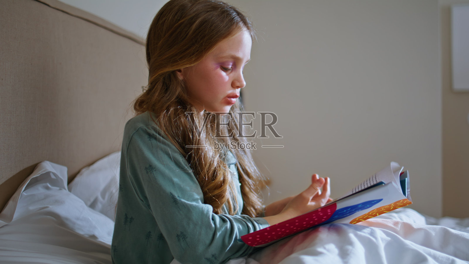 聪明的孩子在近距离观察童话故事中的休息床。小孩的脸上涂着画。照片摄影图片