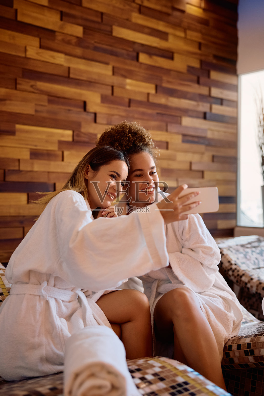 快乐的女性在水疗中心自拍,享受乐趣。照片摄影图片