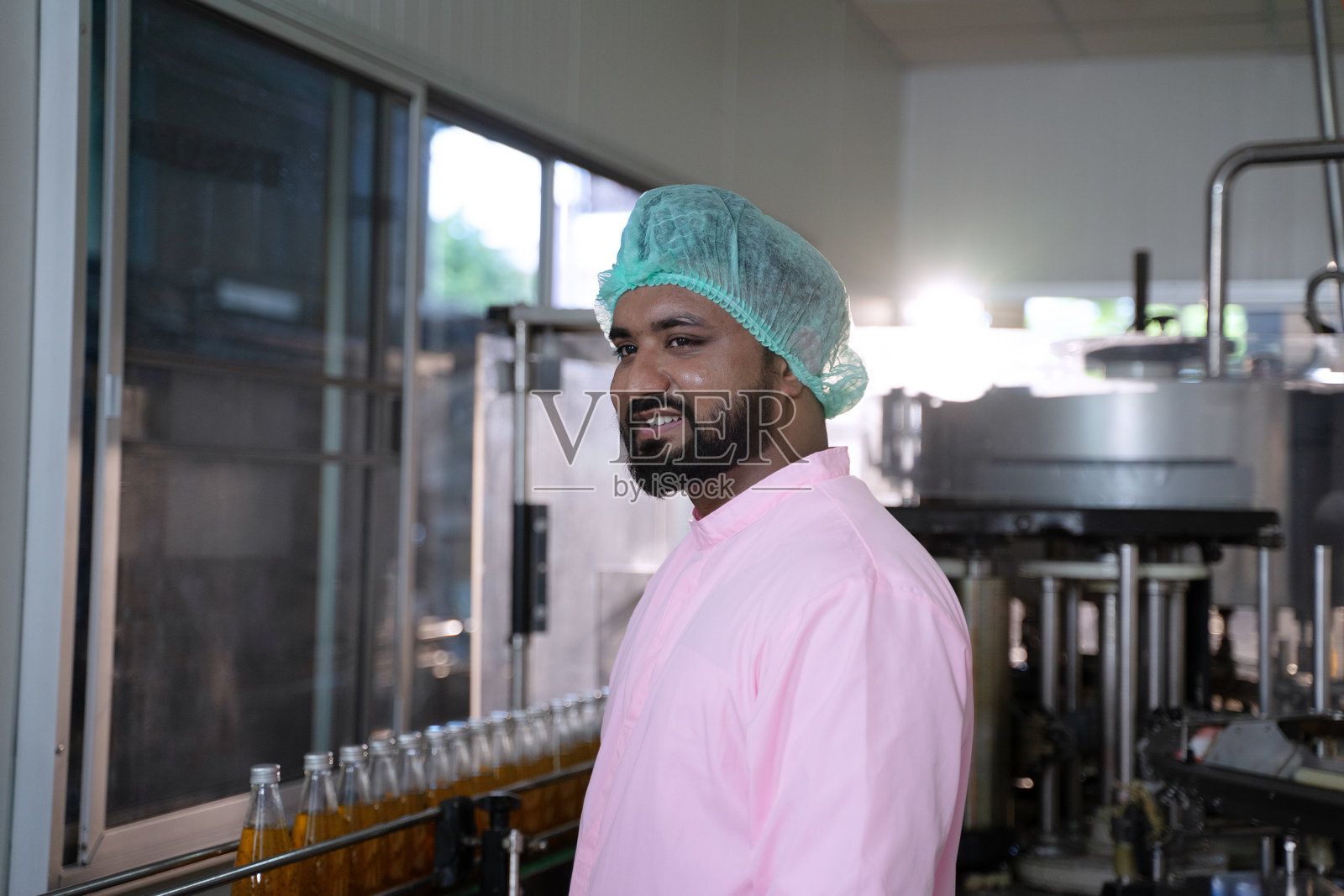 员工在饮料工厂工作。照片摄影图片