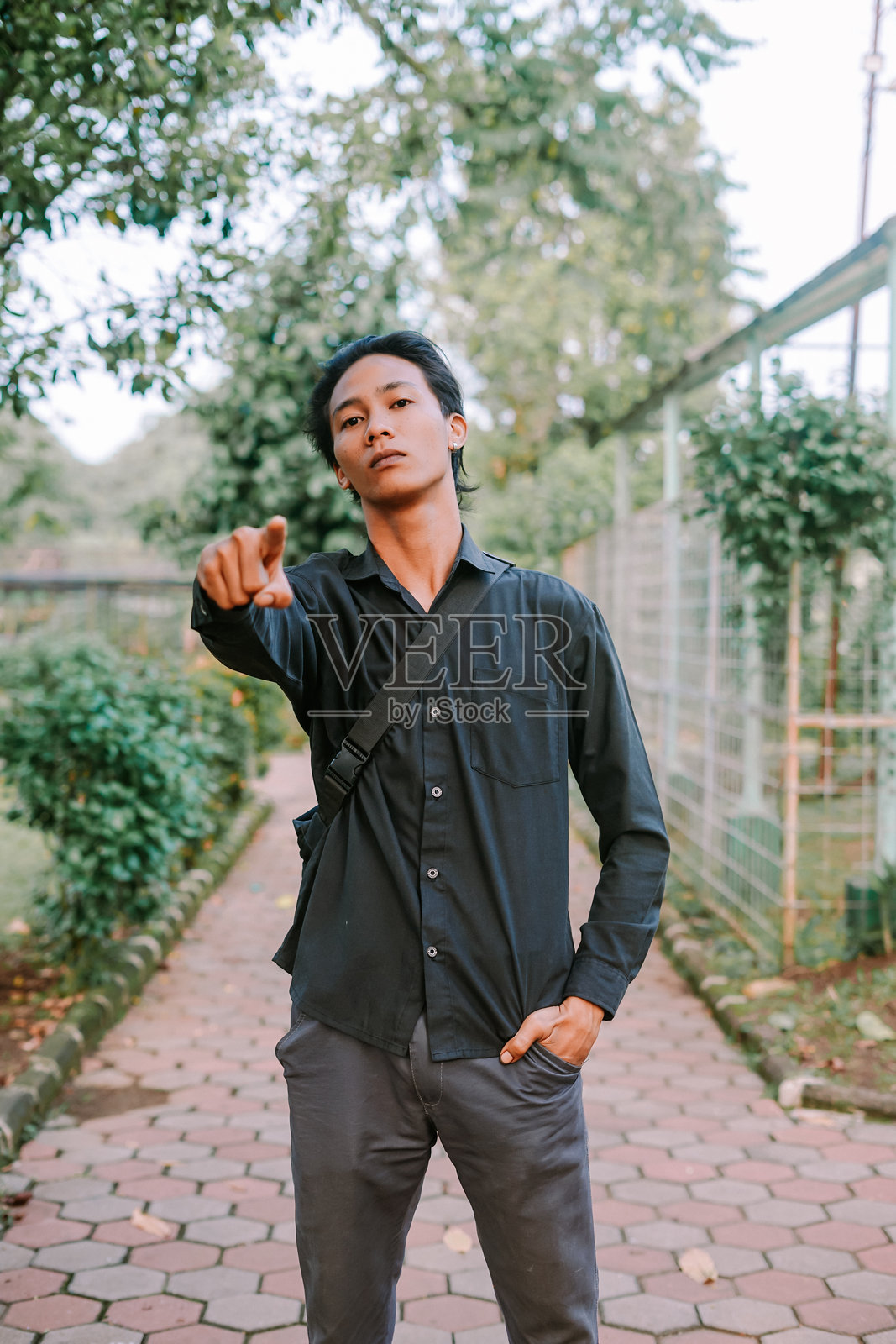 东南亚男子自信地向前指,适合表现方向、引导或专注的主题。照片摄影图片