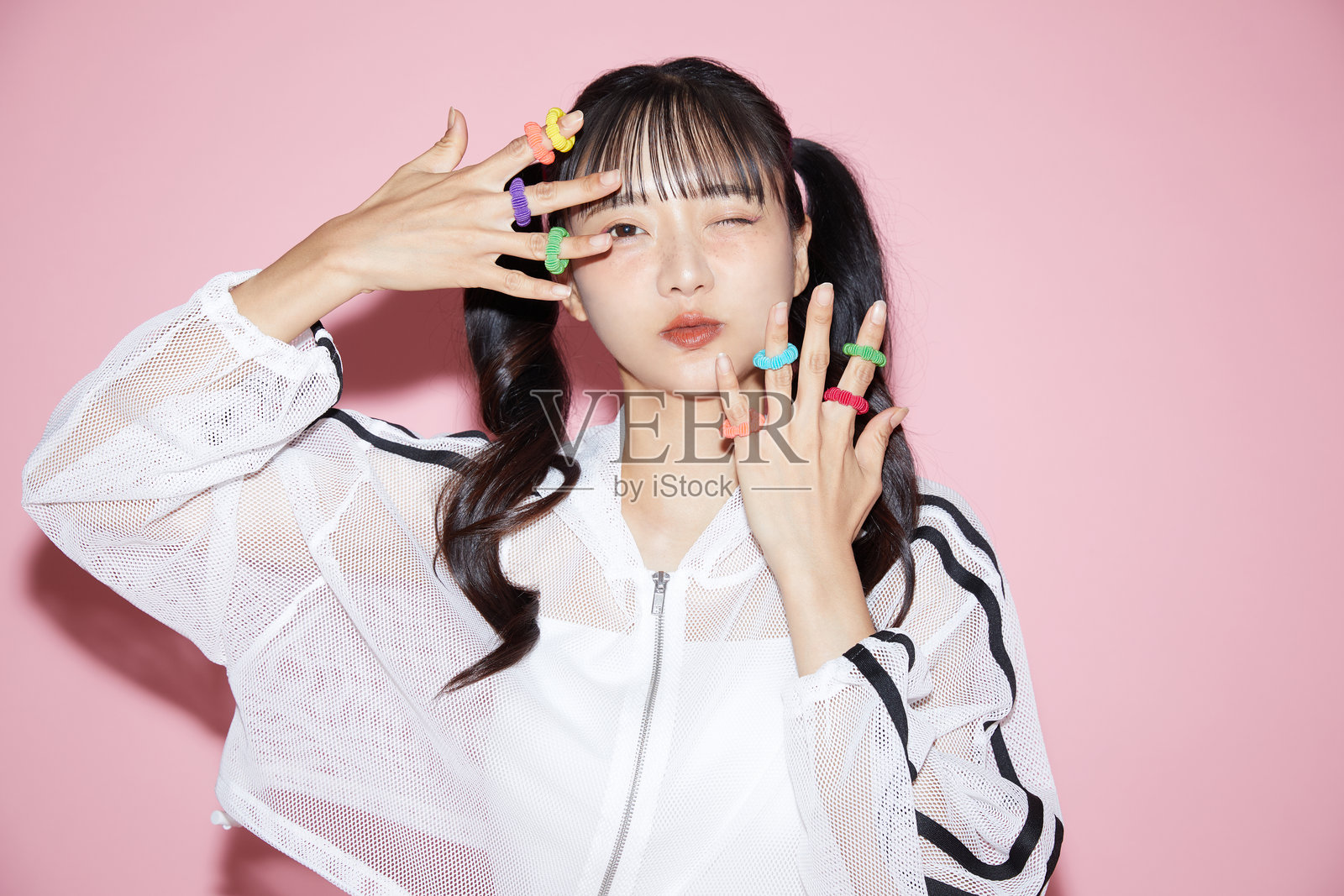 可爱的年轻女性运动服肖像,背景为粉色。照片摄影图片