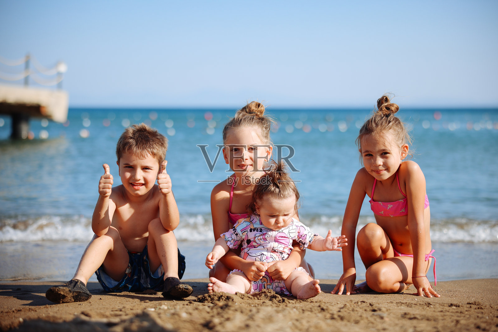 快乐的女孩和男孩在海边尽情玩耍照片摄影图片