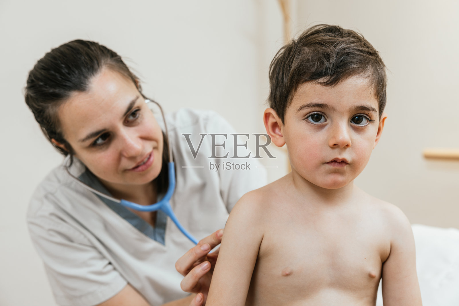 儿科医生用听诊器检查年轻患者的肺部照片摄影图片