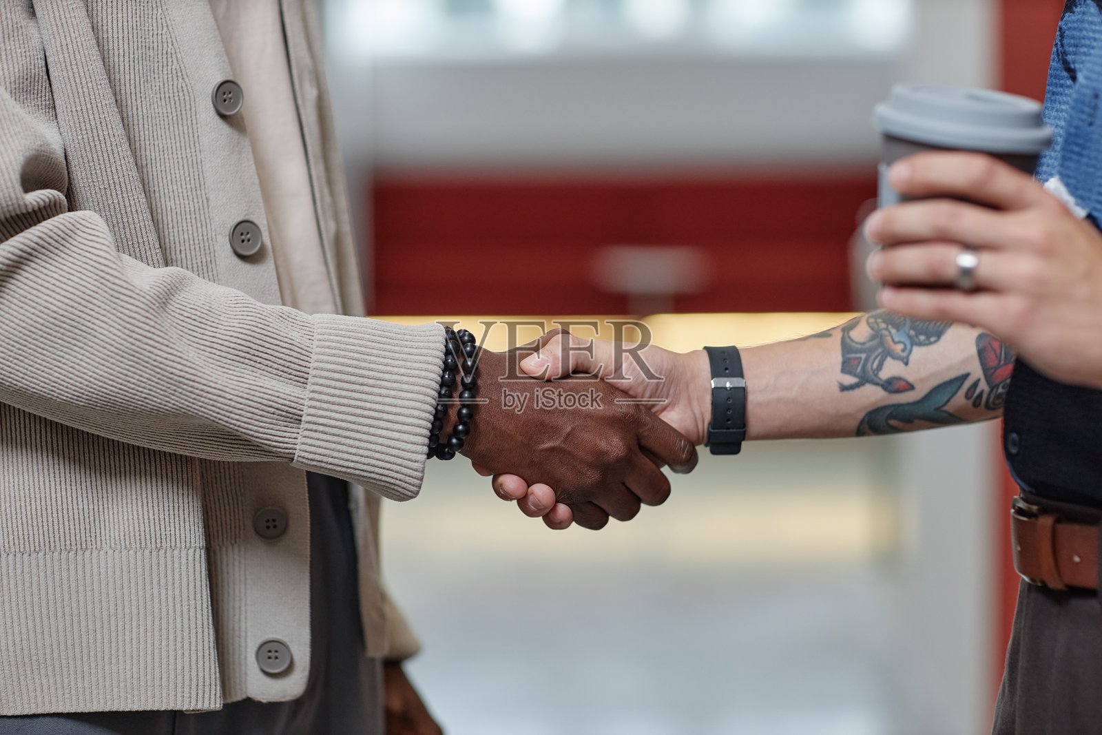 黑人男性在商务中心走廊与男伴握手照片摄影图片